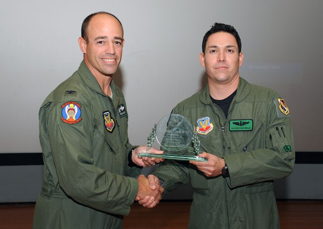 NELLIS AIR FORCE BASE, Nev. -- Col. Michael Gantt, 53d Wing commander, awards Staff Sgt. Christian Corella, 88th Test and Evaluation Squadron aerial gunner, for being an outstanding performer under the Stripes to Exceptional Performers (STEP) program at Nellis Oct. 21. Staff Sgt. Corella played a crucial part in the 23rd Wing disaster response team in New Orleans, Louisiana in the aftermath of Hurricane Katrina.  During a four day period he flew over 35 hours and was responsible for saving 170 American civilian lives. (U.S. Air Force photo by Senior Airman Brett Clashman/Released)