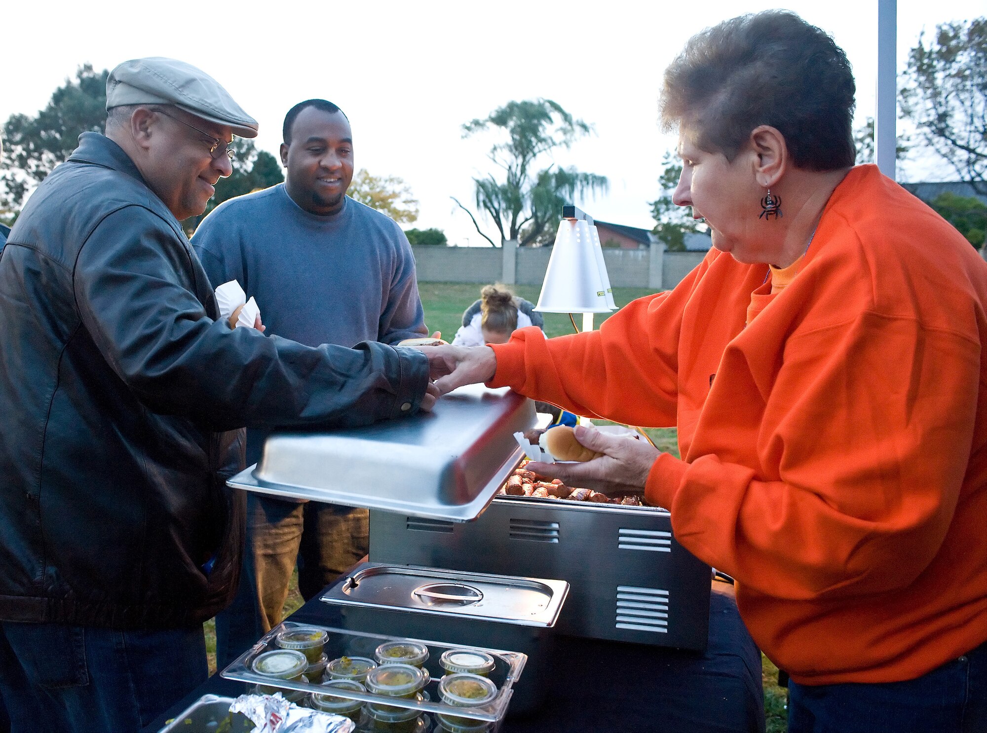 (Left) Tony Lee and his son, David, get a couple of hot dogs from Julie Seward Oct. 30, 2010 at the Harvest Festival and Trunk-R-Treat at the Youth Center, Dover Air Force Base, Del. All food at the Harvest Festival was provided free of charge for all attendees. (U.S. Air Force photo by Roland Balik/Released)