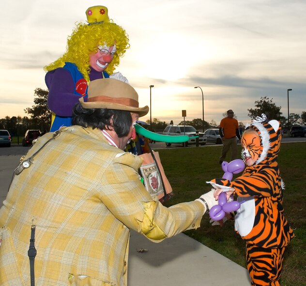 (Right) Tory Ruhm gets a balloon animal from clowns Thomas "Ticker The Watchman" and Evlyn "Dingaling" Bump during the Harvest Festival and Trunk-R-Treat,  Oct. 30, 2010at the Youth Center, Dover Air Force Base, Del. Tory is the daughter of Senior Airman Michael Ruhm, 436th Maintenance Squadron. (U.S. Air Force photo/Roland Balik) (U.S. Air Force photo by Roland Balik/Released)