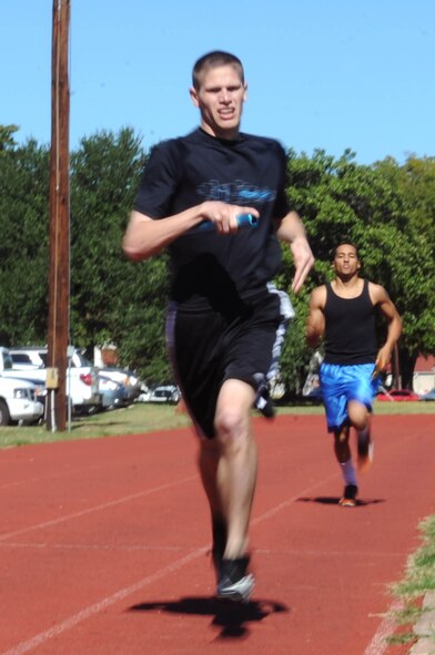 Airmen compete in a 400-meter team relay race during the 2nd Mission Support Group Olympics at Barksdale Air Force Base, La. Oct. 28. Airmen competed in several different sports during the Olympics including soccer, golf, basketball and racquetball. (U.S. Air Force photo/Senior Airman Brittany Y. Bateman)