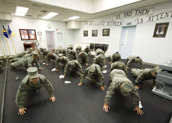 Airmen with the Dover Air Force Base, Del., Honor Guard perform push-ups after uniform inspection Nov. 2, 2010, at Dover. The honor guard perform push-ups any time they make an error as a motivational and correctional tool to emphasize greater attention to detail. (U.S. Air Force Photo/Jason Minto)