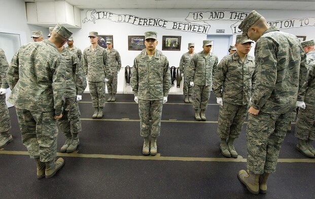 Airmen in the Dover Air Force Base, Del., Honor Guard stands at attention as they are inspected by their trainers during morning formation Nov. 2, 2010. The honor guard performs daily inspections of dress and appearance and completes a set of push-ups for each uniform violation. (U.S. Air Force Photo/Jason Minto) 