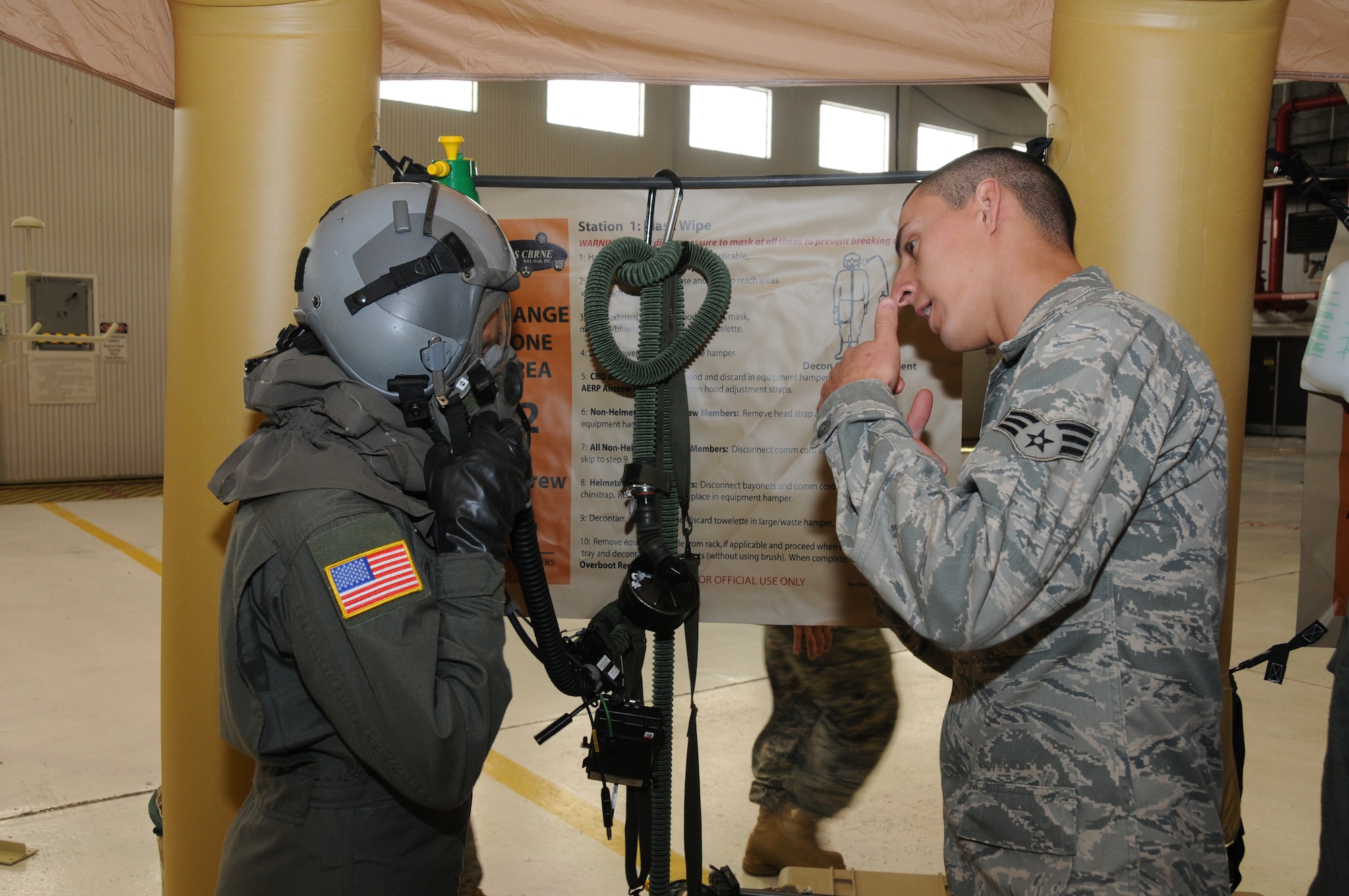 Senior Airman Shawn Niemira from the 107th Aircrew Flight Equipment Squadron instructs loadmaster Tech. Sgt. Katie Swanick from the 136th Airlift Squadron the proper technique in removal of flight helmet/mask. The two were part of an operational readiness exercise recently conducted in preparation for the upcoming operational readiness inspection. (U.S. Air Force photo/Staff Sgt. Peter Dean) 