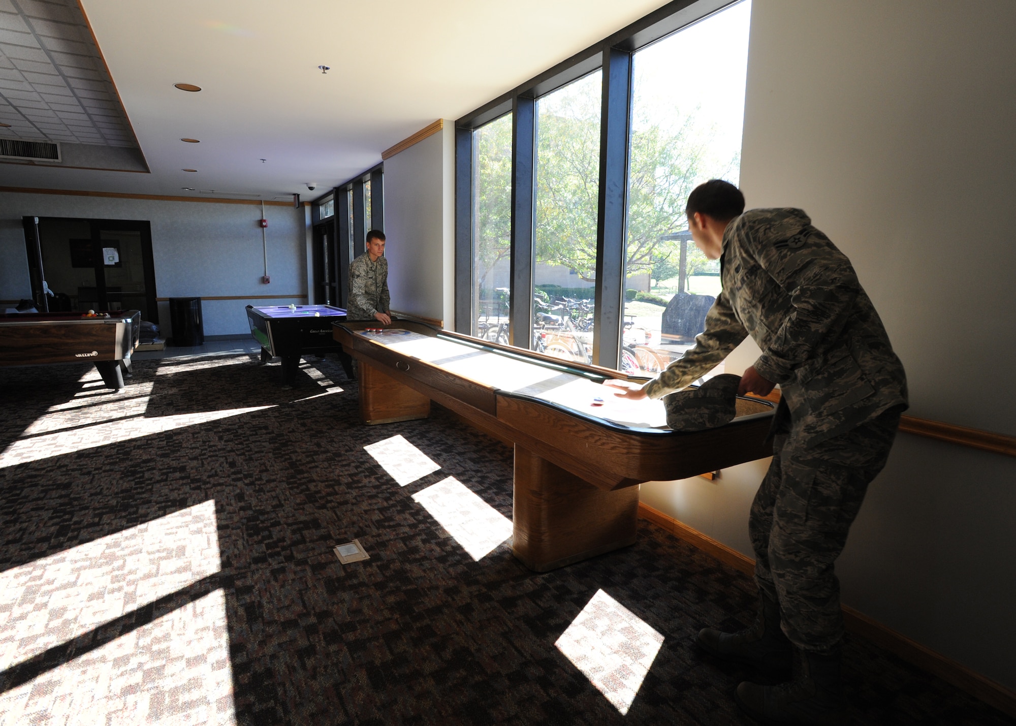 Airman 1st Class Ian McCandless, 22nd Air Refueling Wing military justice paralegal, and Airman 1st Class Chantz Wyant, 22nd Logistics Readiness Squadron fuels distribution apprentice, play shuffleboard inside the dayroom at Taylor Hall, Oct. 15, 2010, McConnell Air Force Base, Kan.  Each dormitory building’s dayroom features a variety of entertainment options such as pool tables and large flat-screen televisions for Airmen to use off-duty. (U.S. Air Force photo/Airman 1st Class Andrea Salazar)
