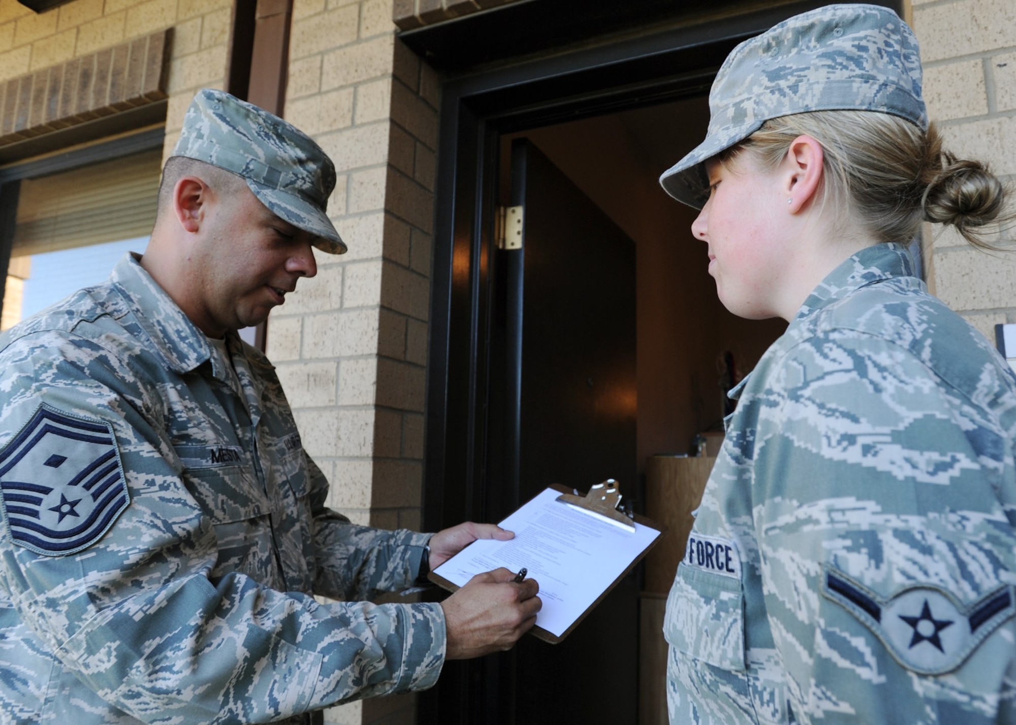 Senior Master Sgt. Nathan Mesta, 22nd Aircraft Maintenance Squadron first sergeant, shows Airman Emily Randall, 22nd Logistics Readiness Squadron flight-service center apprentice, a room inspection checklist for McConnell’s dormitories, Oct. 15, 2010, McConnell Air Force Base, Kan.  Dorm managers inspect each unit at least quarterly. Room inspections are conducted to ensure the health all dorm residents, and to establish a model Airmen may use when they are able to reside off-base.  (U.S. Air Force photo/Airman 1st Class Andrea Salazar)