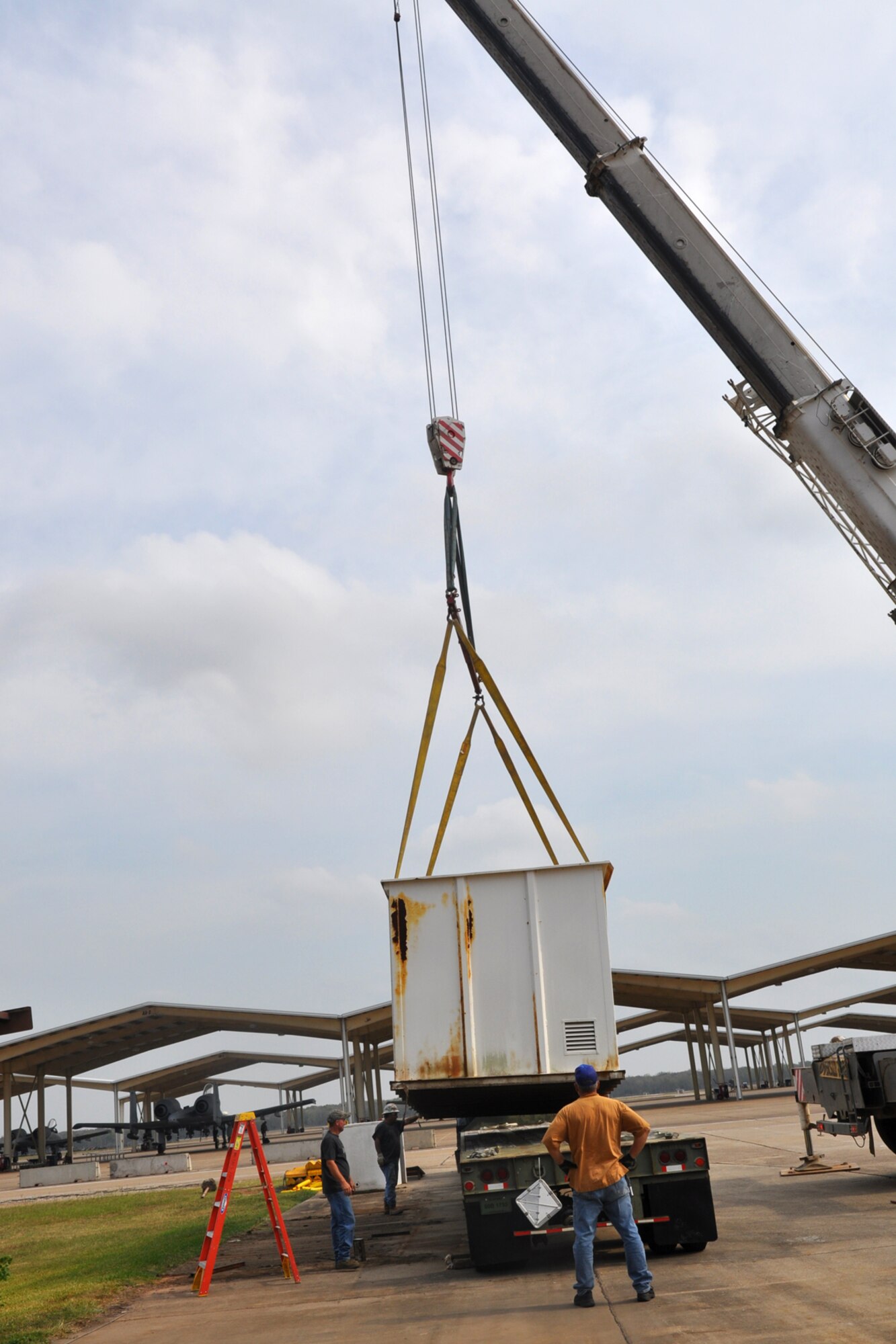 A large crane lifts a storage container onto a flat-bed trailer next to the 917th Maintenance Squadron’s Metals Technology building on Barksdale Air Force Base, La., Oct. 22, 2010. Due to the every changing world of technology and advances in fabrication equipment, the 917th Wing is expanding the present structure by adding additional work space to the first floor and office spaces to the second floor. The shop deals with the fabrication of aircraft parts or air ground equipment for the 917th Wing. The addition of the advanced equipment will give greater capabilities to the shop to accomplish their mission. (U.S. Air Force photo/Betty Stephens)