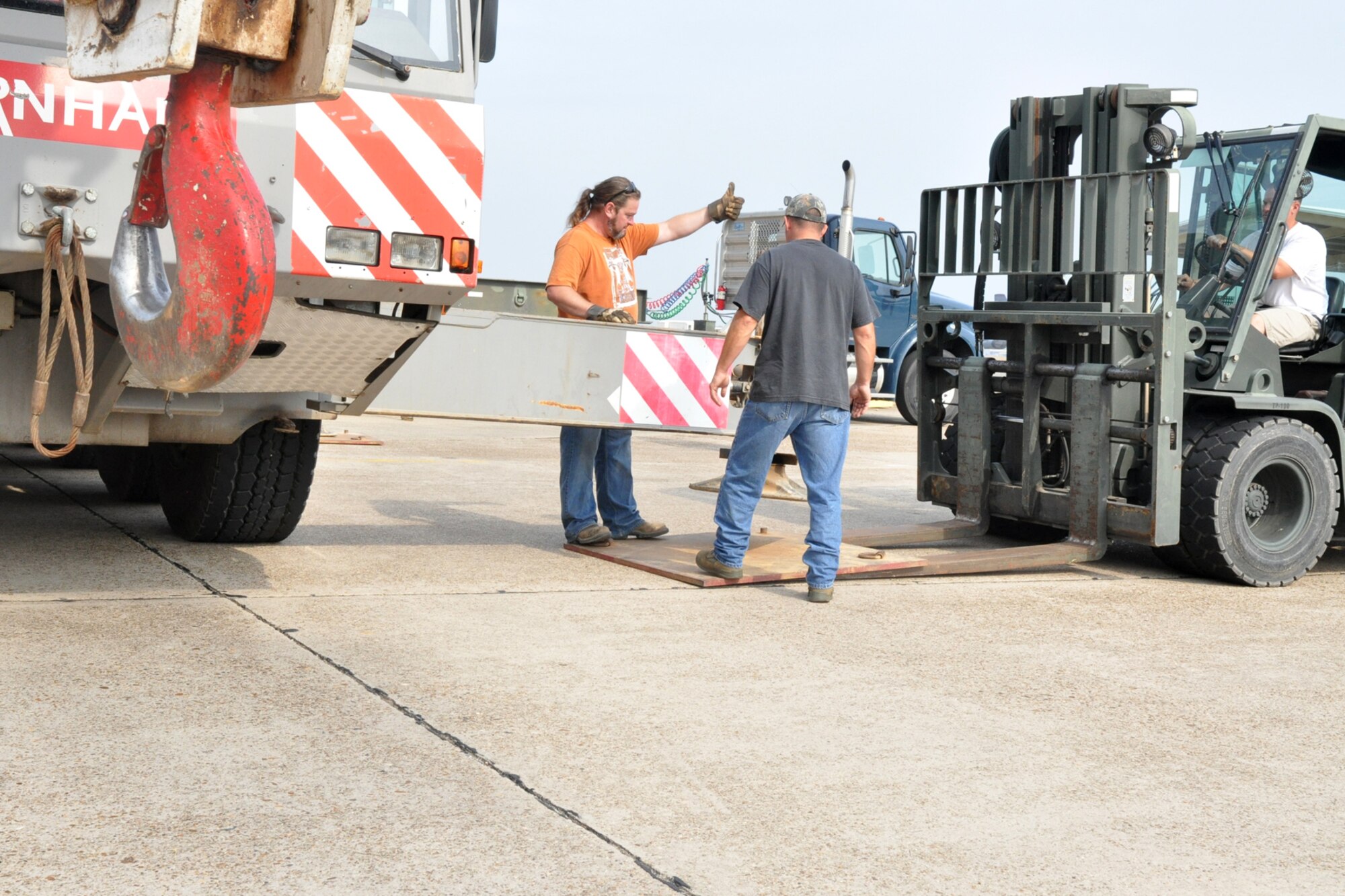 Workers place a thick metal plate on the cement to protect it from the weight of the crane that will move a storage container at the 917th Maintenance Squadron’s Metals Technology building on Barksdale Air Force Base, La., Oct. 22, 2010. Due to the every changing world of technology and advances in fabrication equipment, the 917th Wing is expanding the present structure by adding additional work space to the first floor and office spaces to the second floor. The shop deals with the fabrication of aircraft parts or air ground equipment for the 917th Wing. The addition of the advanced equipment will give greater capabilities to the shop to accomplish their mission. (U.S. Air Force photo/Betty Stephens)  