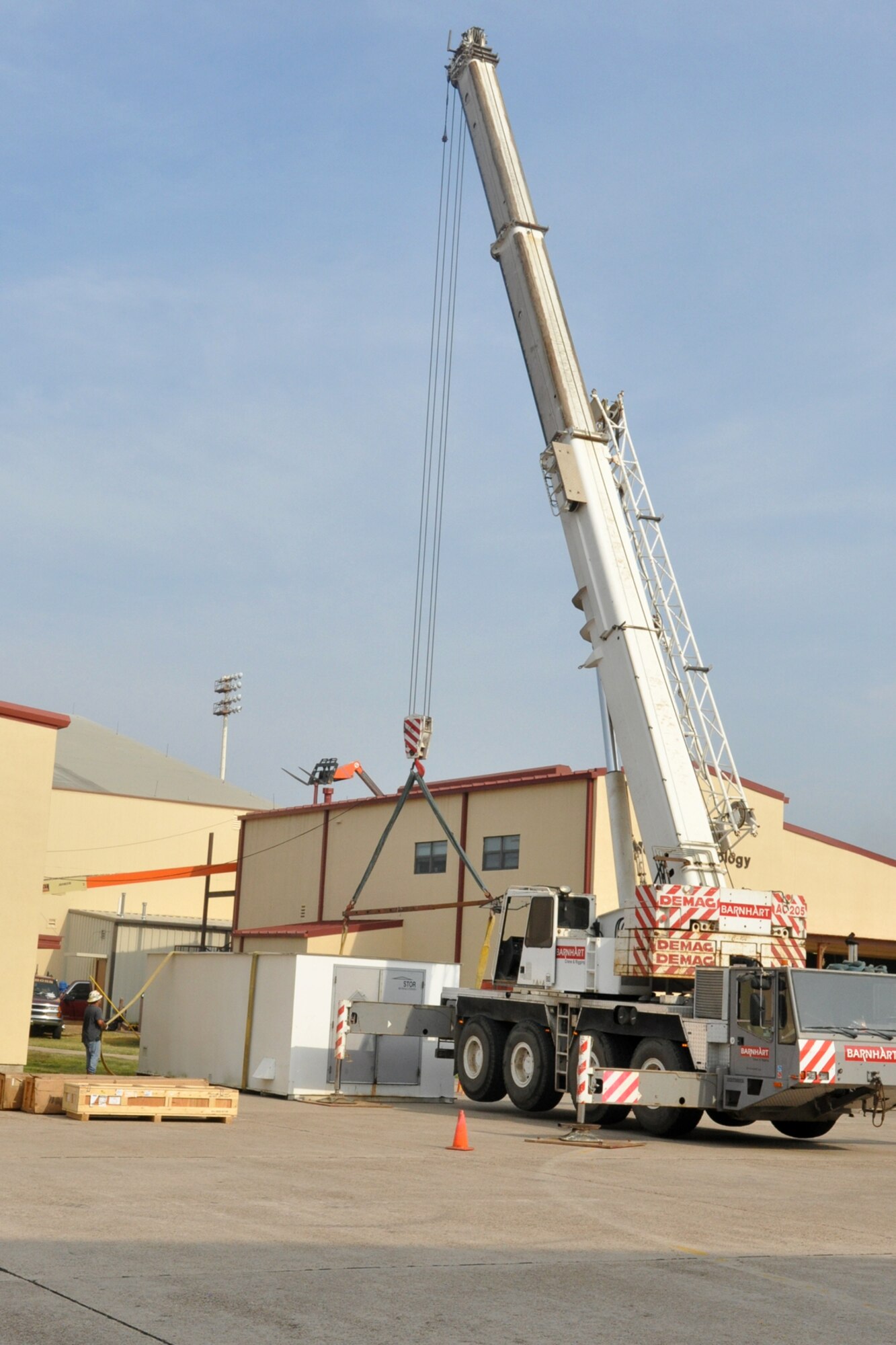 In preparation for planned construction, workers prepare to remove a storage container next to the 917th Maintenance Squadron’s Metals Technology building on Barksdale Air Force Base, La., Oct. 22, 2010. Due to the every changing world of technology and advances in fabrication equipment, the 917th Wing is expanding the present structure by adding additional work space to the first floor and office spaces to the second floor. The shop deals with the fabrication of aircraft parts or air ground equipment for the 917th Wing. The addition of the advanced equipment will give greater capabilities to the shop to accomplish their mission. (U.S. Air Force photo/Betty Stephens)  