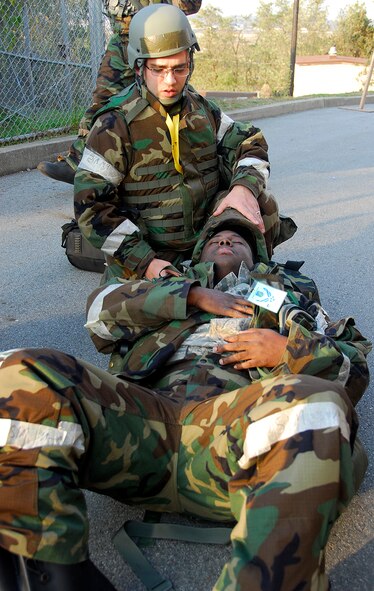 Staff Sgt. Timothy Clay, 51st Civil Engineer Squadron, provides medical aide to Staff Sgt. Rico Stowers, 51st Maintenance Operations Squadron, after he suffers a simulated chest injury Nov. 3 at Osan Air Base, Republic of Korea, during exercise Beverly Midnight 10-02. The exercise allows Airmen to demonstrate their ability to complete the mission in simulated chemical environments while executing their primary duties, practicing self aid and buddy care, conducting post-attack reconnaissance and unexploded ordnance sweeps. (U.S. Air Force photo/Staff Sgt. Eunique Stevens)