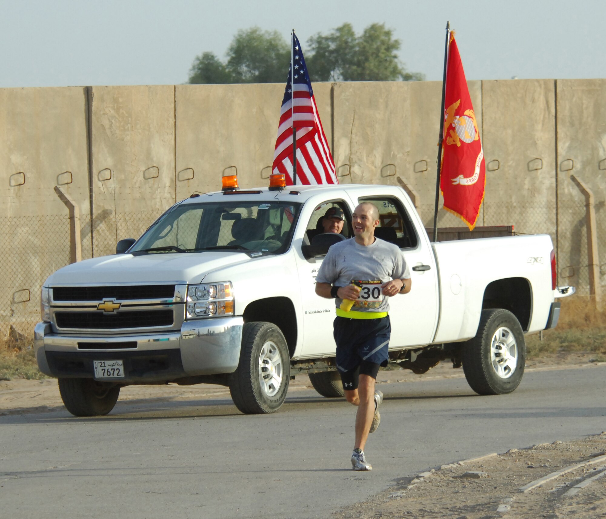 Tech. Sgt. Brian Morris, 777th Expeditionary Aircraft Maintenance Unit electronic warfare systems craftsman, passes the lead vehicle in the Marine Corps Marathon to cross the finish line with a top time of 3:10:07 Oct. 31, 2010, Joint Base Balad, Iraq.  The marathon was 26 miles long, winding around and through the base. More than 100 Airmen, Soldiers, Sailors, Marines and civilians registered for the 4 a.m. start.  Sergeant Morris deployed from Little Rock, Ark., is a native of Cabot, Ark. (U.S. Air Force photo/Senior Master Sgt. Thomas Wood)