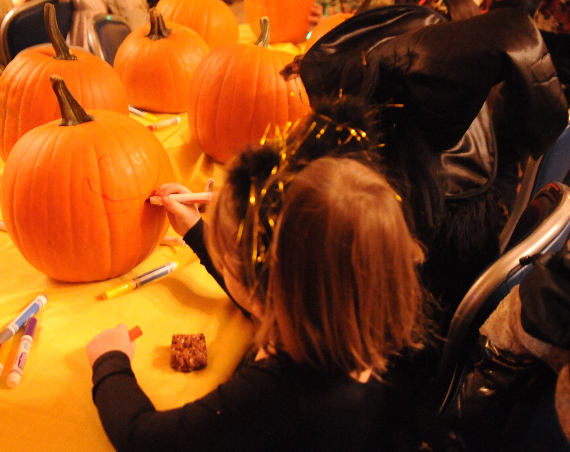 A child draws a face on the pumpkin at the Fall Festival Oct. 29, 2010, Eielson Air Force Base. The fall festival included various activities from around base such as carnival games from the youth center, a coloring activity from the fitness center, pumpkin decorating from the community center and the commissary, and face painting from the 354th FSS Human Resources office. U.S. Air Force photo/ Airman 1st Class Janine Thibault)