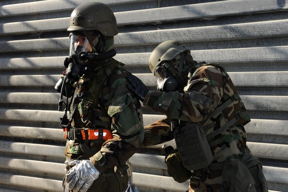 KUNSAN AIR BASE, Republic of Korea -- Chief Master Sgt. James Sanders, 8th Fighter Wing command chief, performs a buddy check on another Wolf Pack member Nov. 3 to ensure proper wear of chemical gear during exercise Beverly Midnight 10-05. Proper wear of all issued chemical and individual protection equipment gear issued is vital to mission success whether during an exercise or in a deployed location. (U.S. Air Force photo/Staff Sgt. Jonathan Pomeroy)