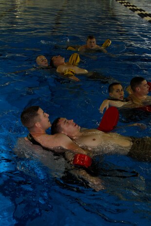 Station Marines run through drills designed to teach them how to save the life of a drowning victim during a three-week Marine Combat Instructor of Water Survival course at the IronWorks Gym pool here Nov. 4. Marines are both physically and mentally tested through various written and physically demanding exams.
