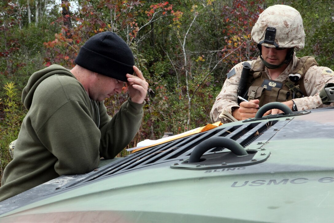 Two explosive ordnance disposal technicians with EOD Company, 8th Engineer Support Battalion, 2nd Marine Logistics Group, review details about a mission during Improvised Explosive Device Response training at Camp Dave South Training Ground, one of the many training areas aboard Camp Lejeune, N.C., Nov. 4, 2010. During the training, EOD technicians were given the opportunity to brush up on their skills and find simulated IEDs scattered throughout the training grounds by fellow technicians. (U.S. Marine Corps photo by Pfc. Franklin E. Mercado)