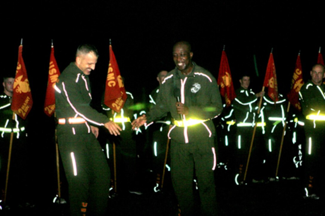 Brig. Gen. Michael Dana, 2nd Marine Logistics Group commanding general, passes a microphone to sergeant major of the Marine Corps, Sgt. Maj. Carlton W. Kent, to address the Marines and sailors of 2nd MLG after a fun run aboard Camp Lejeune, N.C., Nov. 4, 2010.  Kent spoke of past traditions in recognition of the Marine Corps’ 235th birthday.  (U.S. Marine Corps photo by Lance Cpl Anthony Kidd)