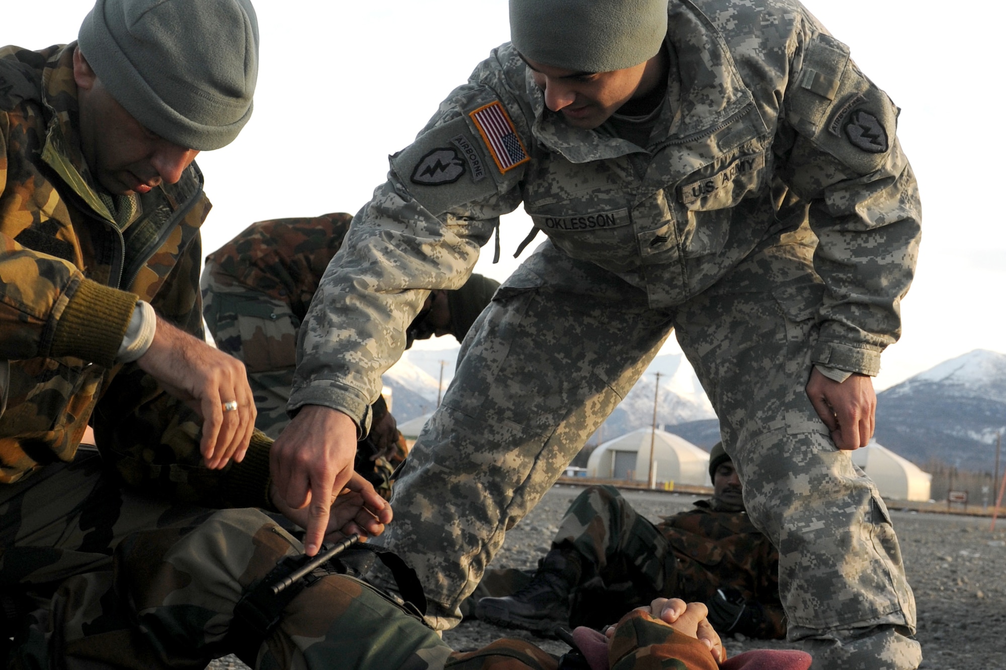 Sgt. Dakota Oklesson, Apache Troop, 1st Squadron (Airborne), 40th Cavalry Regiment, 4th Brigade Combat Team (Airborne), 25th Infantry Division, a senior line medic, helps an Indian soldier apply a tourniquet during their first day of training for Yudh Abhyas 2010, Monday, at the Battle Command Training Center and Education Center on Joint Base Elmendorf-Richardson. (U.S. Army photo/Spc. Ashley Armstrong)