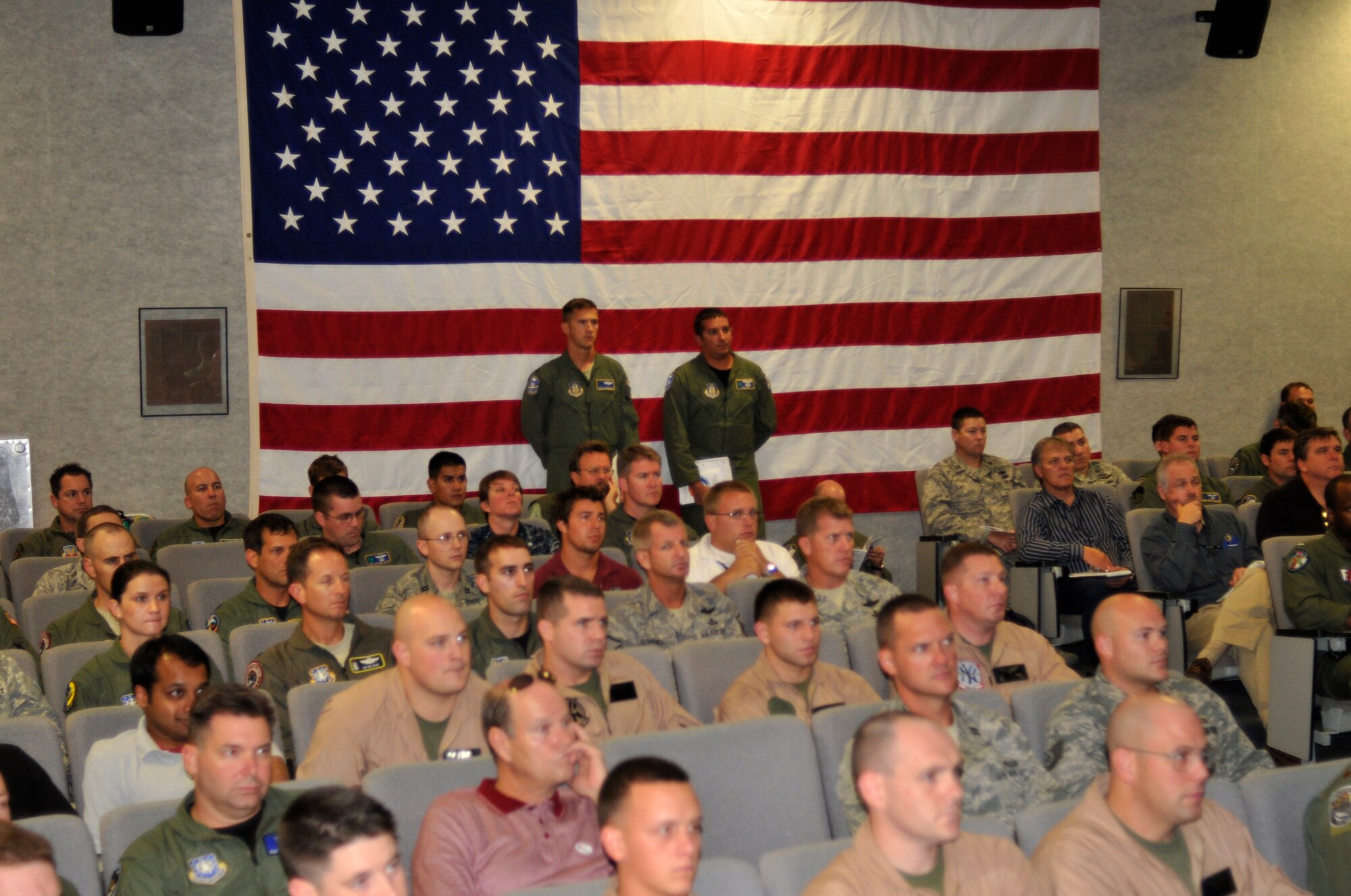 PATRICK AIR FORCE BASE, Fla. - HH-60G Pave Hawk pilots, Captains Paul Carpenter and Jason Tomas, 301st Rescue Squadron, listen along with nearly 100 other servicemembers from all five DoD branches and NASA civilians at the 301st RQS here Nov. 2 in preparation of their support for the emergency portion of the space shuttle Discovery launch Nov. 5. It's the last launch of Discovery and the third to the last space shuttle launch. (U.S. Air Force photo/Capt. Cathleen Snow)