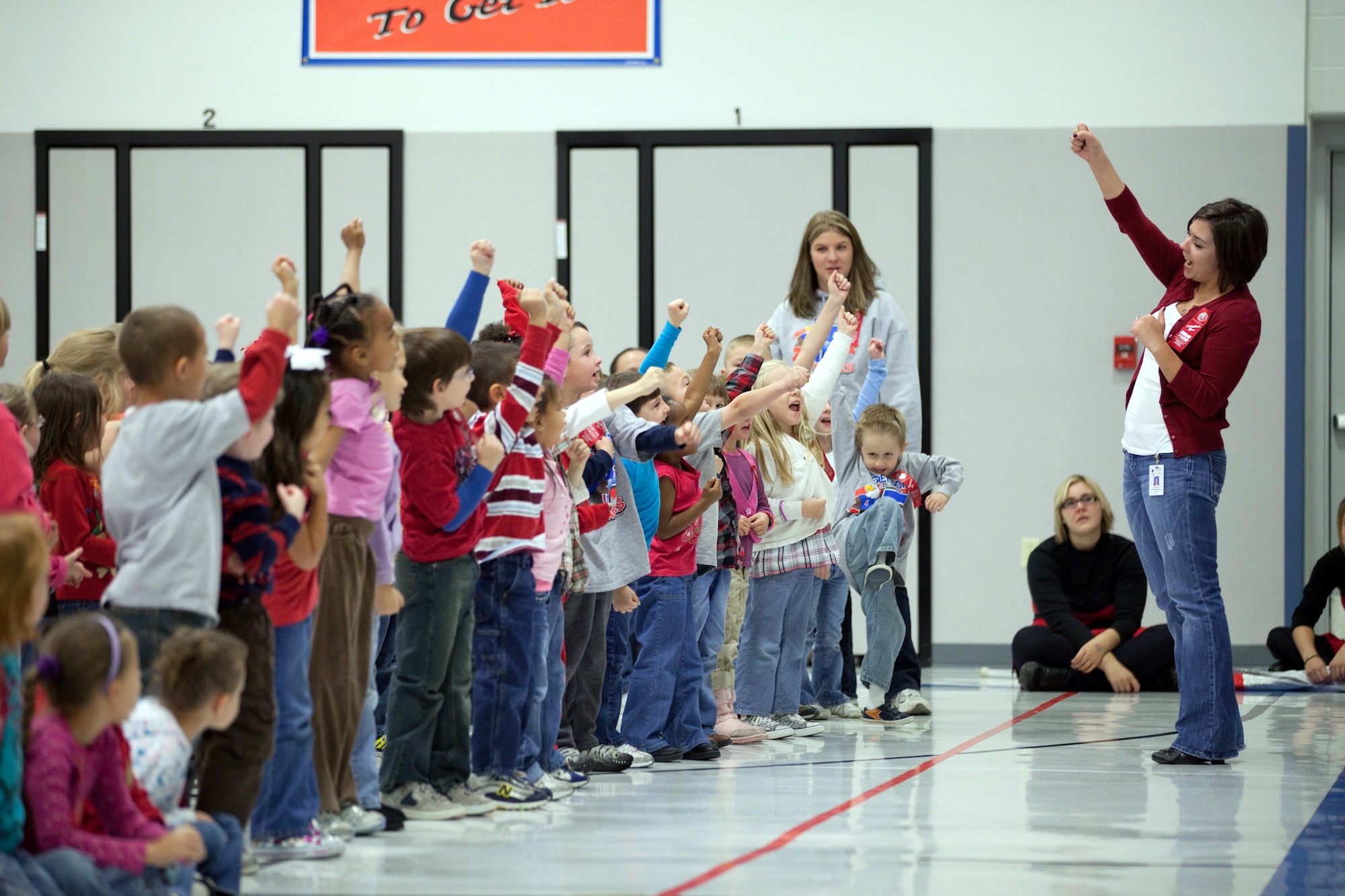Stacey Gray, a teacher at Freedom Elementary School, leads two kindergarten classes in an anti-drug cheer during the Red Ribbon Week assembly at Freedom Elementary School on Oct. 27. (U.S. Air Force photo by Jeff Allred)