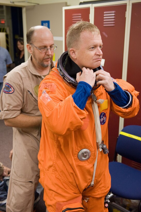NASA astronaut U.S. Air Force Col. Eric Boe, STS-133 pilot, dons a training version of his shuttle launch and entry suit Sept. 24 in preparation for a training session in the Space Vehicle Mock-up Facility at NASA's Johnson Space Center. United Space Alliance suit technician Steve Sholtz assisted Boe. (Courtesy photo/James Blair, NASA)