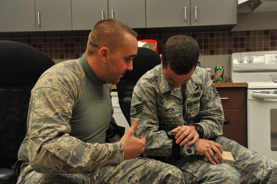 Staff Sgts Daniel Hunsinger and Tanner Tilton, 341st Civil Engineer Squadron Explosive Ordinance Disposal technicians, enter coordinates into a GPS unit before departing for a dismounted improvised explosive device night-operation exercise Oct. 26. (U.S. Air Force photo/John Turner)