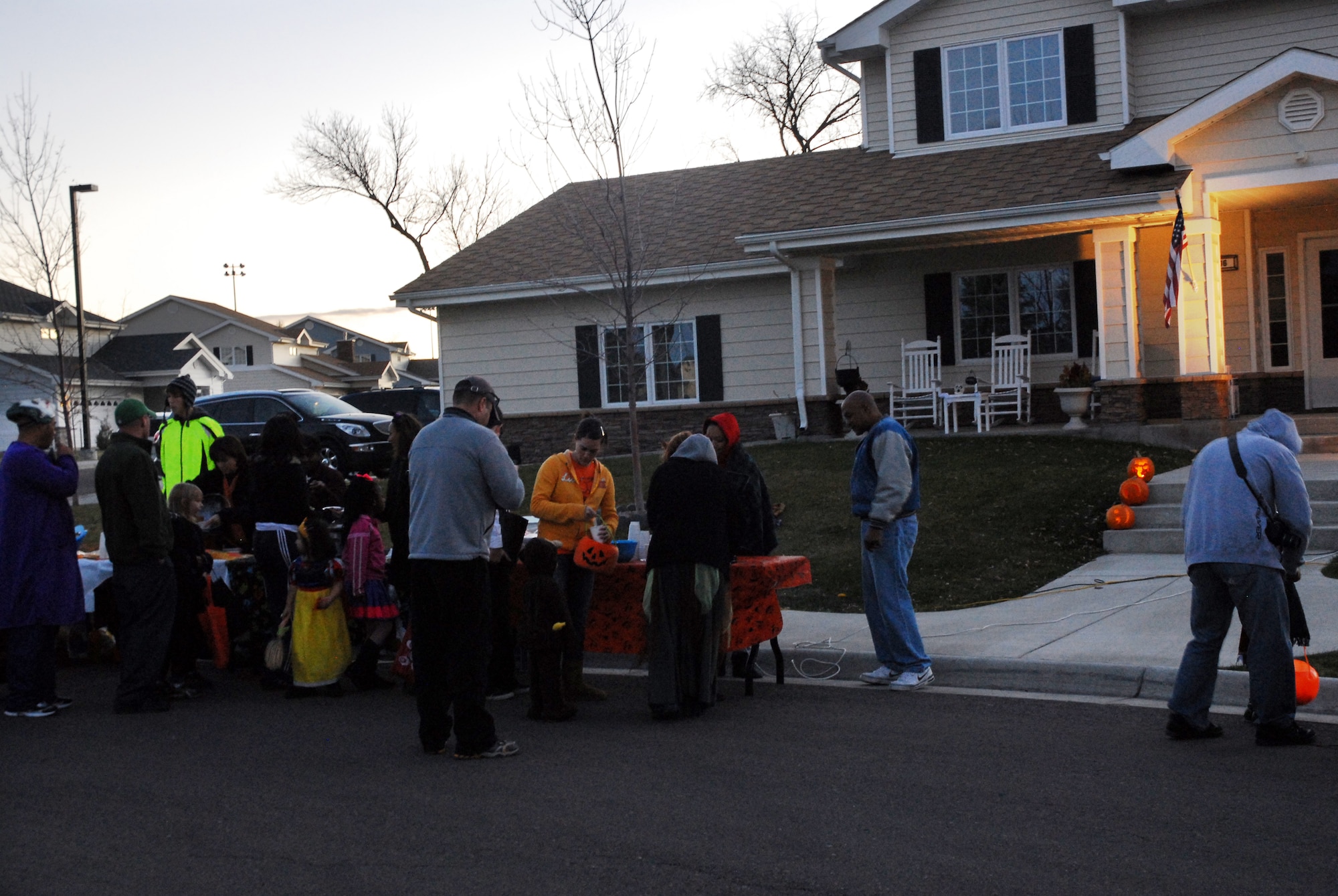 Malmstrom Total Force Airmen, civilian employees and families pass Col. Anthony Cotton's house Halloween night for free hot drinks and food served by wing leadership. (U.S. Air Force photo/Staff Sgt. Dillon White)