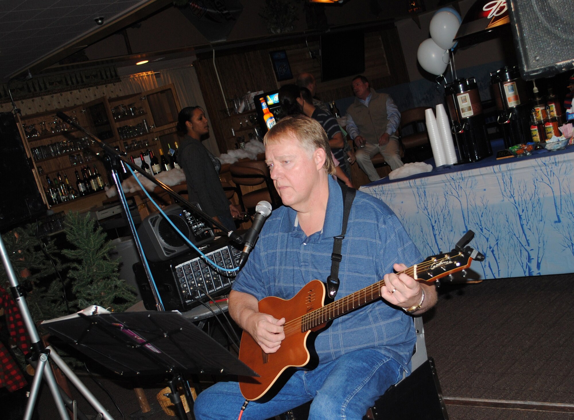Dave Martinson plays soft music in the background for those in attendance at the Ski Expo and Dessert and Wine Fair at the Grizzly Bend Club Oct. 28. The event is held annually, showcasing desserts, meats and beverages from vendors statewide representatives offer information about resorts, lodging, sports and cross-country trails for the upcoming snow season. (U.S. Air Force photo/Airman 1st Class Kristina Overton)