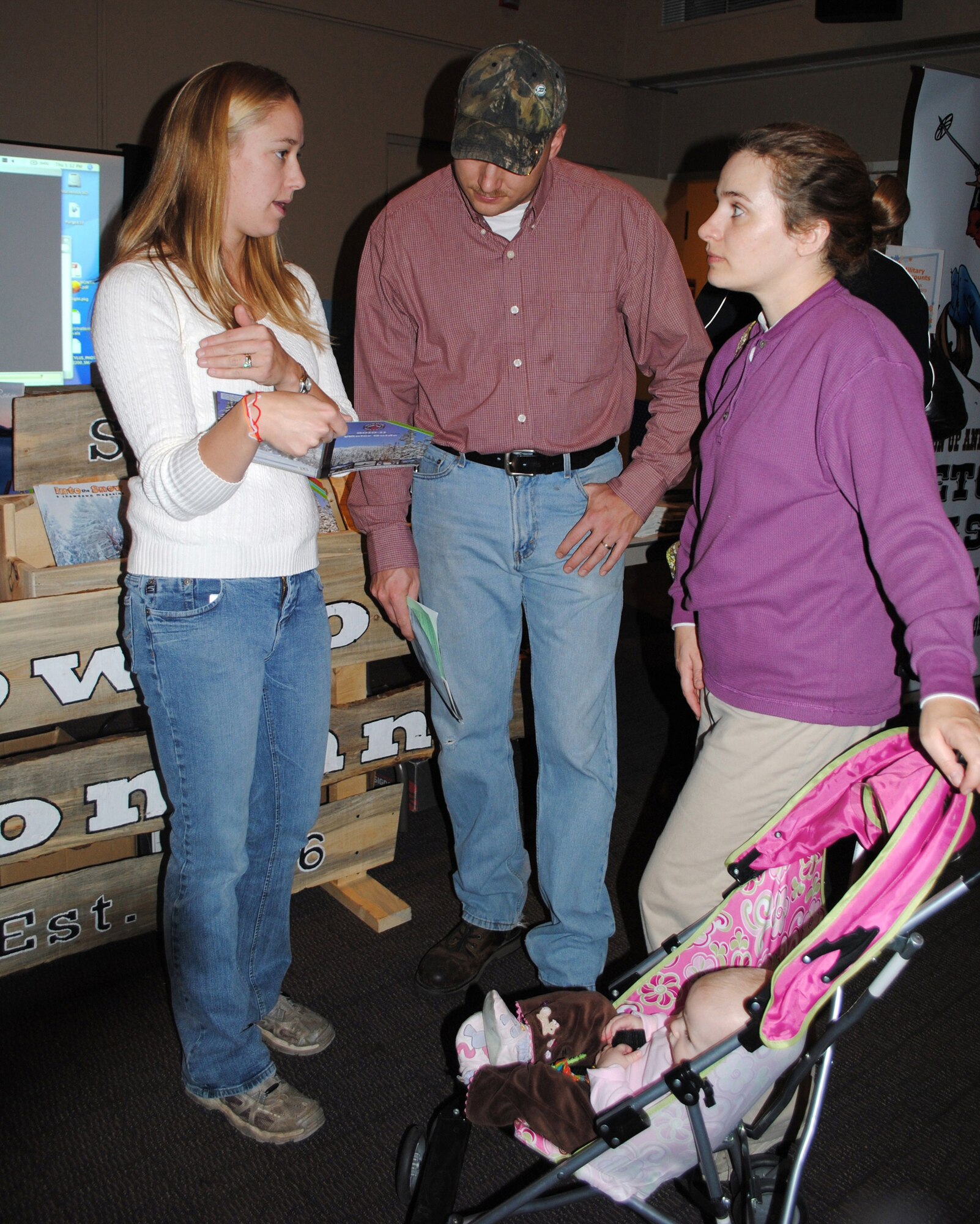 Jessie Willet, Showdown Montana Ski Resort marketing representative, shares some information about the resort's upcoming winter season with Tech. Sgt. George Springer, 341st Missile Maintenance Squadron facility maintenance NCOIC, and his wife, Jennifer. (U.S. Air Force photo/Airman 1st Class Kristina Overton)