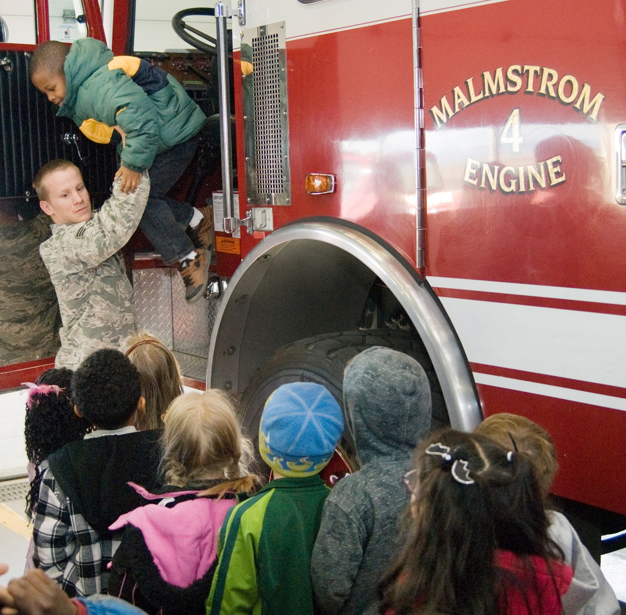 Senior Airman Scott Avis, 341st Civil Engineering Squadron firefighter,  shows students from Loy Elementary School what it is like to drive a fire truck at the  Malmstrom Air Force Base Fire Station Oct. 27. (U.S. Air Force Photo/Beau Wade)
