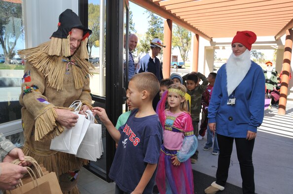 Col. Michael Moran, Space Development and Test Wing commander, hands out bags Oct. 29 to trick-ortreaters from Kirtland Elementary School inside the SDTW headquarters building.
