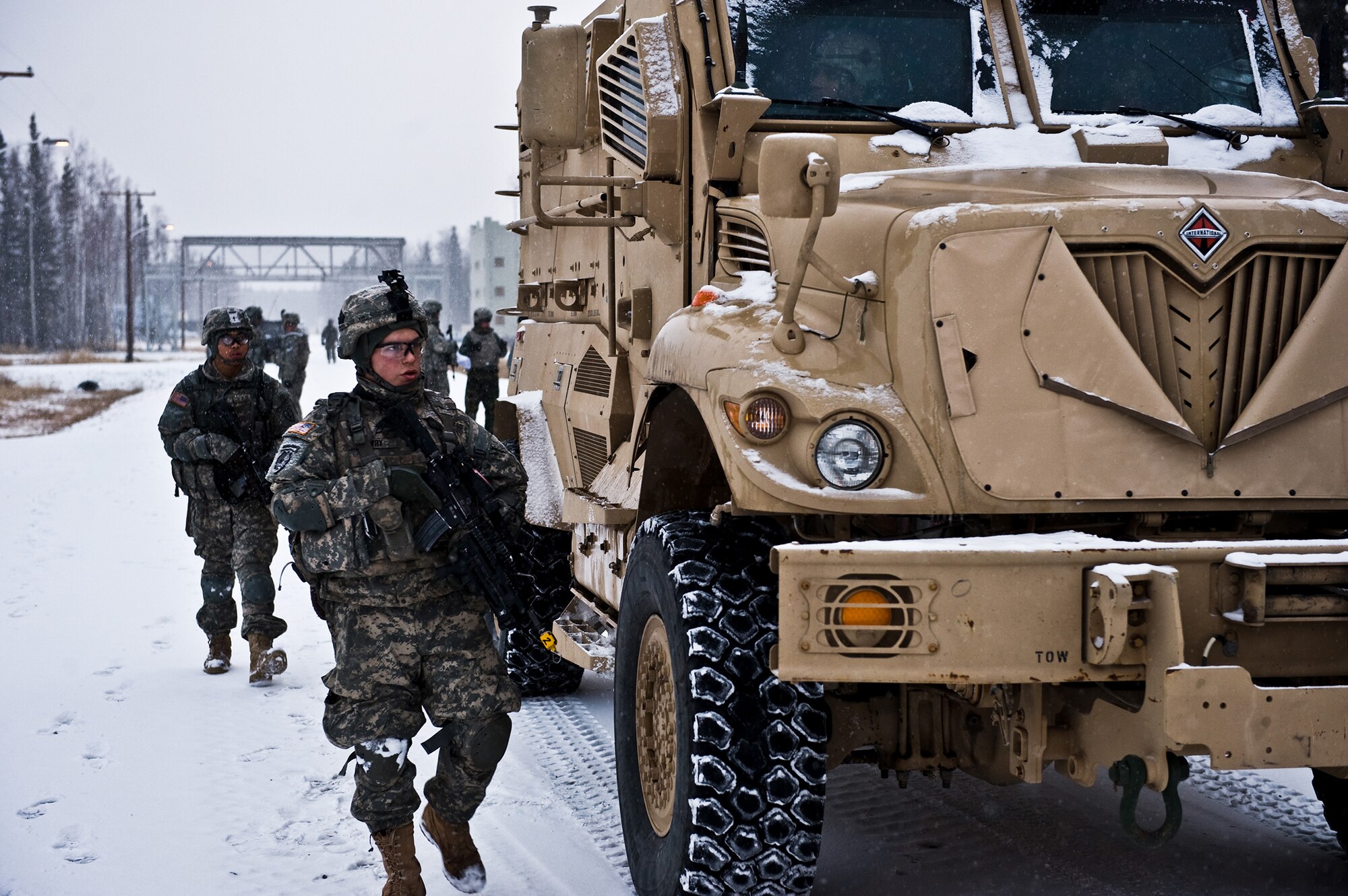 FORT GREELY, Alaska ? Soldiers of the 2nd Platoon, C Company, 1st Battalion, 501st Infantry Regiment (Airborne) walk along side a Mined Resistant Ambush Protection vehicle while on ?patrol? during a training exercise Oct. 29. Soldiers from the 501st IR participated in field-training exercises, with the first elements arriving to Donnelly Training Area, Fort Greely, Alaska Oct. 14 and the last of the Soldiers scheduled to leave Nov. 10. (U.S. Air Force photo/Airman 1st Class Christopher Gross)
