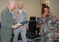 Technical Sgt. Jeffrey March, 919th Communications Squadron, right,  reacts as Col. Andy Comtois, 919th Special Operations Wing commander, left, and Chief Master Sgt.  Michael Klausutis, 919th SOW command chief, present his new stripes during a surprise promotion ceremony Oct. 2 at Duke Field.   Sergeant March was one of eight Duke Field reservists awarded immediate Promotion Enhancement Program promotions during the wing’s October unit training assembly. The PEP is a commander’s program designed to promote outstanding and well-deserving Air Force Reserve Airmen one grade above the authorized grade for their position.  Only those Airmen who show outstanding potential are considered based on a demonstrated ability to serve in the next higher grade.  (Courtesy photo)
