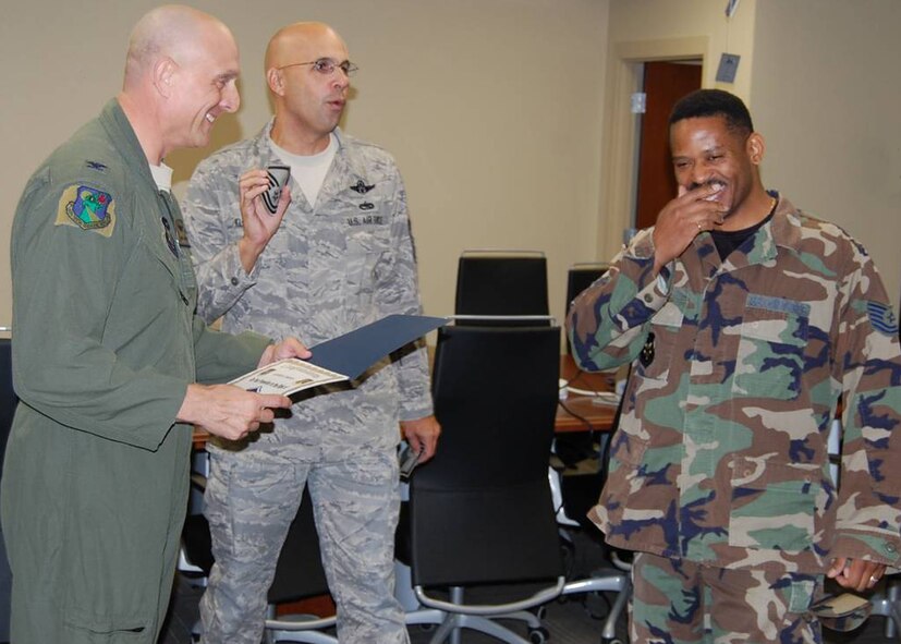Technical Sgt. Jeffrey March, 919th Communications Squadron, right,  reacts as Col. Andy Comtois, 919th Special Operations Wing commander, left, and Chief Master Sgt.  Michael Klausutis, 919th SOW command chief, present his new stripes during a surprise promotion ceremony Oct. 2 at Duke Field.   Sergeant March was one of eight Duke Field reservists awarded immediate Promotion Enhancement Program promotions during the wing’s October unit training assembly. The PEP is a commander’s program designed to promote outstanding and well-deserving Air Force Reserve Airmen one grade above the authorized grade for their position.  Only those Airmen who show outstanding potential are considered based on a demonstrated ability to serve in the next higher grade.  (Courtesy photo)