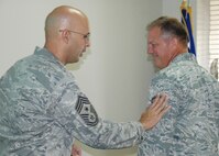 Master Sgt. Michael Lonon, 919th Maintenance Squadron, right,  reacts as Chief Master Sgt.  Michael Klausutis, 919th Special Operations Wing command chief, “tacks on” his new stripes during a surprise promotion ceremony Oct. 2 at Duke Field.   Sergeant Lonon was one of eight Duke Field reservists awarded immediate Promotion Enhancement Program promotions during the wing’s October unit training assembly. The PEP is a commander’s program designed to promote outstanding and well-deserving Air Force Reserve Airmen one grade above the authorized grade for their position.  Only those Airmen who show outstanding potential are considered based on a demonstrated ability to serve in the next higher grade.  (U.S. Air Force photo/Dan Neely)