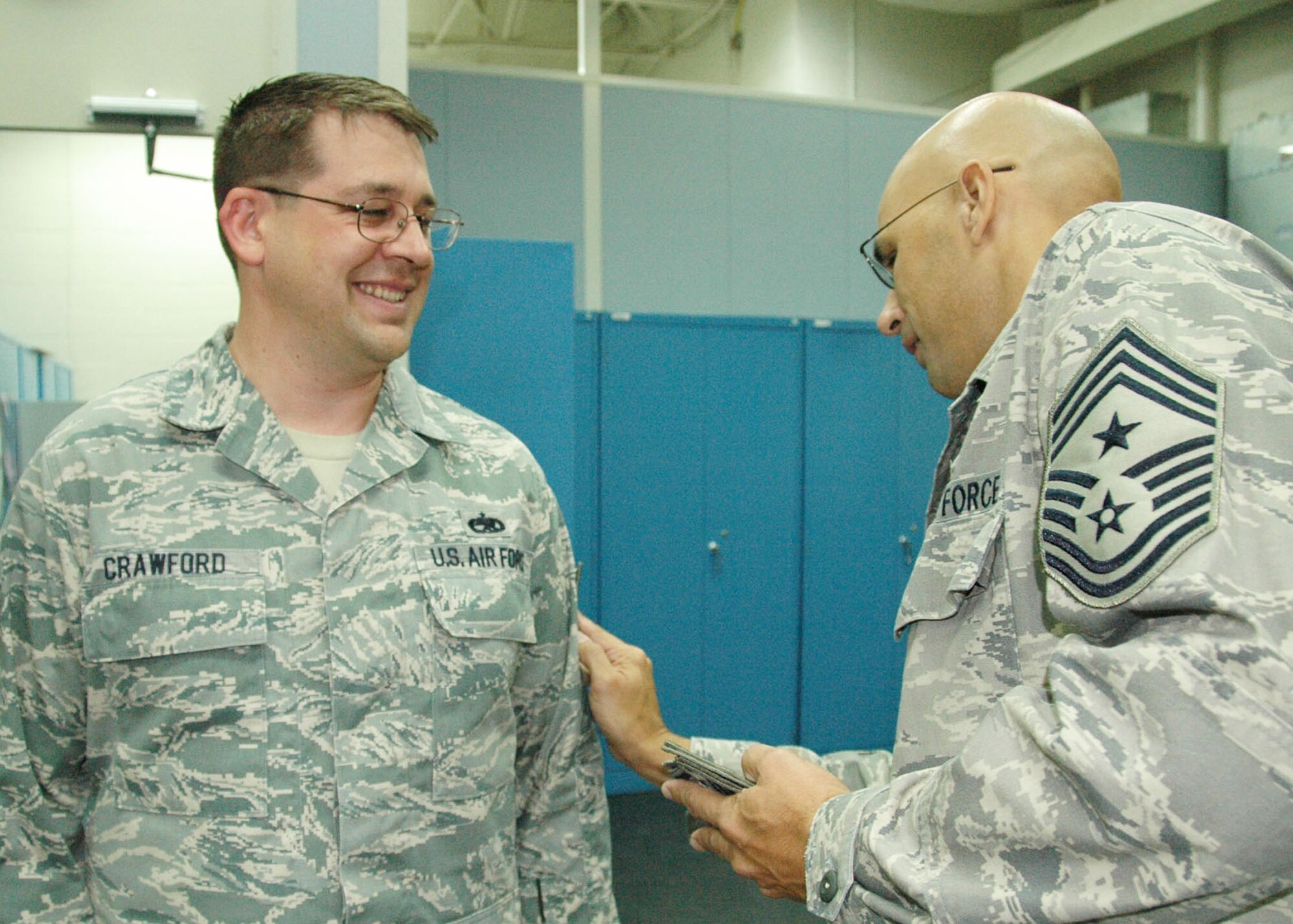 Technical Sgt. Adam Crawford, 919th Maintenance Squadron, reacts as Chief Master Sgt.  Michael Klausutis, 919th Special Operations Wing command chief, “tacks on” his new stripes during a surprise promotion ceremony Oct. 2 at Duke Field.   Sergeant Crawford was one of eight Duke Field reservists awarded immediate Promotion Enhancement Program promotions during the wing’s October unit training assembly. The PEP is a commander’s program designed to promote outstanding and well-deserving Air Force Reserve Airmen one grade above the authorized grade for their position.  Only those Airmen who show outstanding potential are considered based on a demonstrated ability to serve in the next higher grade.  (U.S. Air Force photo/Dan Neely)