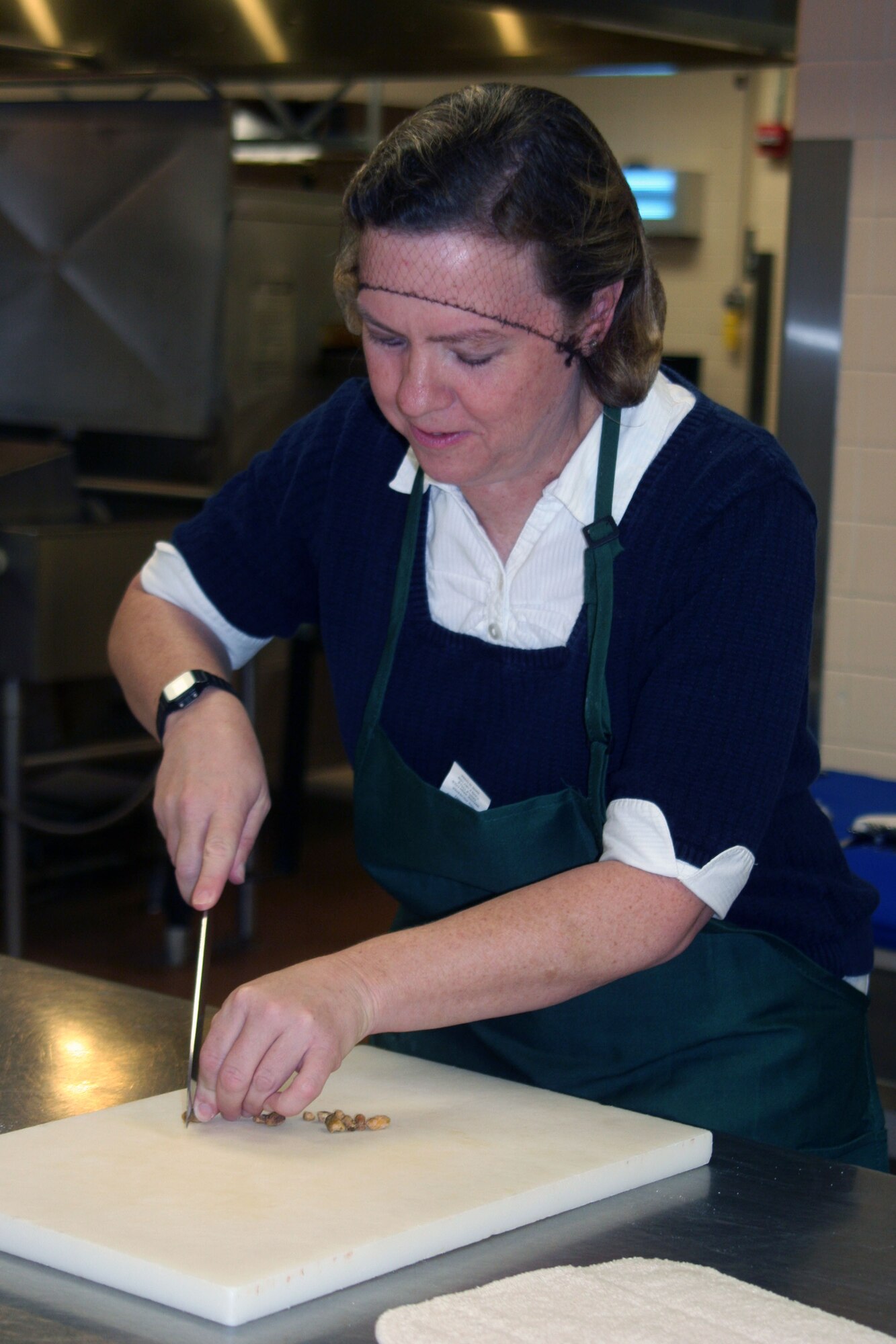 WRIGHT-PATTERSON AIR FORCE BASE, Ohio – Stacy Vaughn, 445th Airlift Wing Public Affairs, is cooking her holiday cranberry-orange pistachio bars for the 3rd Annual Wright-Patt Culinary Competition on Nov. 3 at the Wright-Patterson Air Force Base hospital dining room. Stacy chops pistachios and prepared her dish to bake in the oven. (U.S. Air Force photo/Susan Belna)