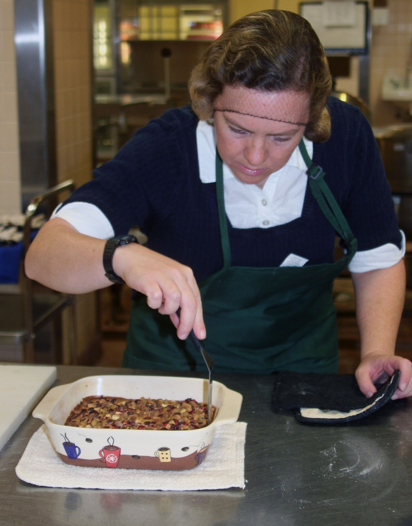 WRIGHT-PATTERSON AIR FORCE BASE, Ohio – Stacy Vaughn, 445th Airlift Wing Public Affairs, is cooking her holiday cranberry-orange pistachio bars for the 3rd Annual Wright-Patt Culinary Competition on Nov. 3 at the Wright-Patterson Air Force Base hospital dining room. Stacy checks her dish to ensure it is fully cooked. (U.S. Air Force photo/Susan Belna)