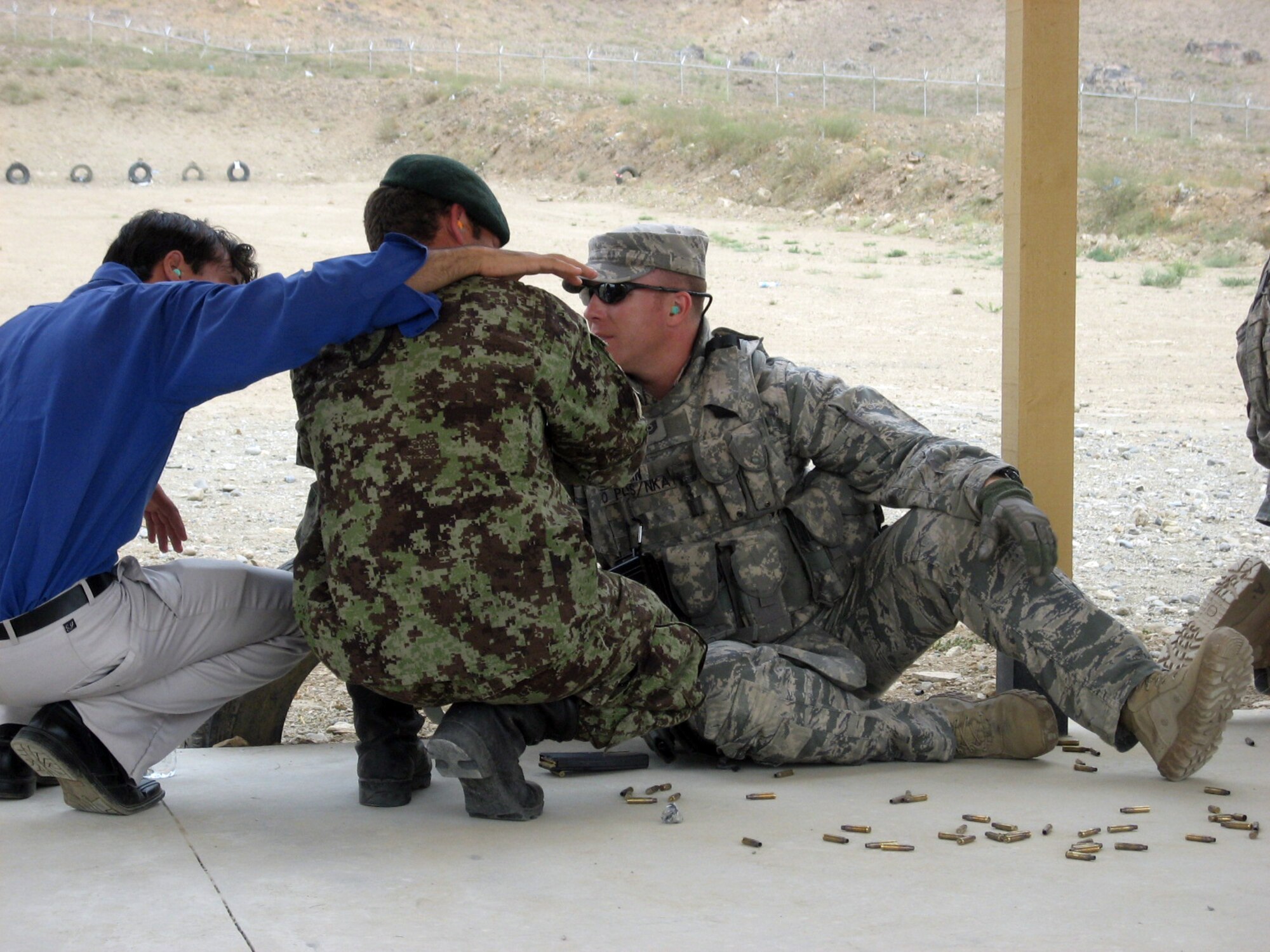 Tech. Sgt. Chad Vaughn assists an Afghan soldier during some shooting practice on a range near Kabul, Afghanistan. Sergeant Vaughn is deployed from the 27th Special Operations Security Forces Squadron, Cannon AFB, N.M. (Courtesy photo)