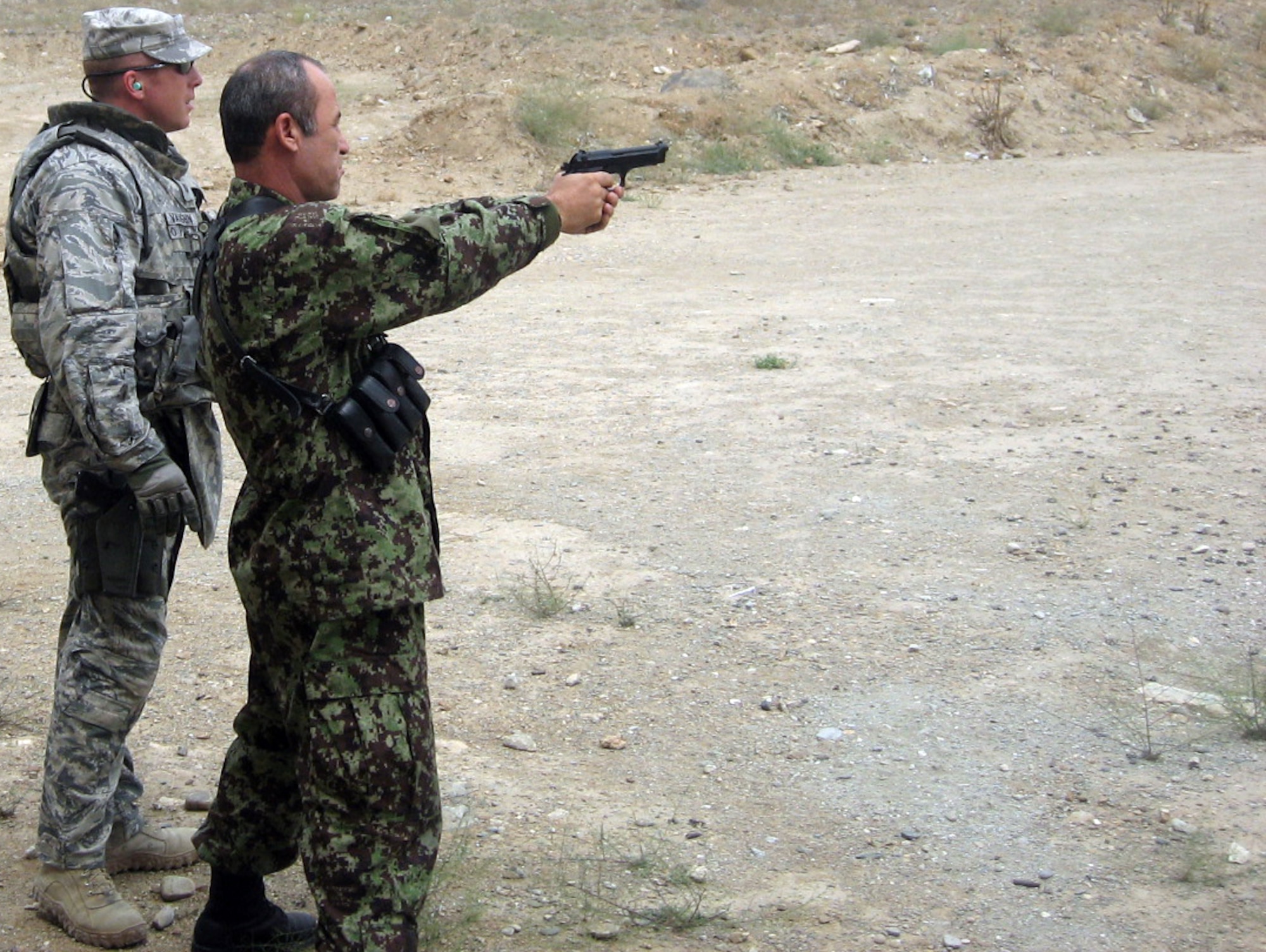 Tech. Sgt. Chad Vaughn assists an Afghan colonel on the shooting range during training near Kabul. Sergeant Vaughn is deployed from the 27th Special Operations Security Forces Squadron, Cannon AFB, N.M. (Courtesy photo)