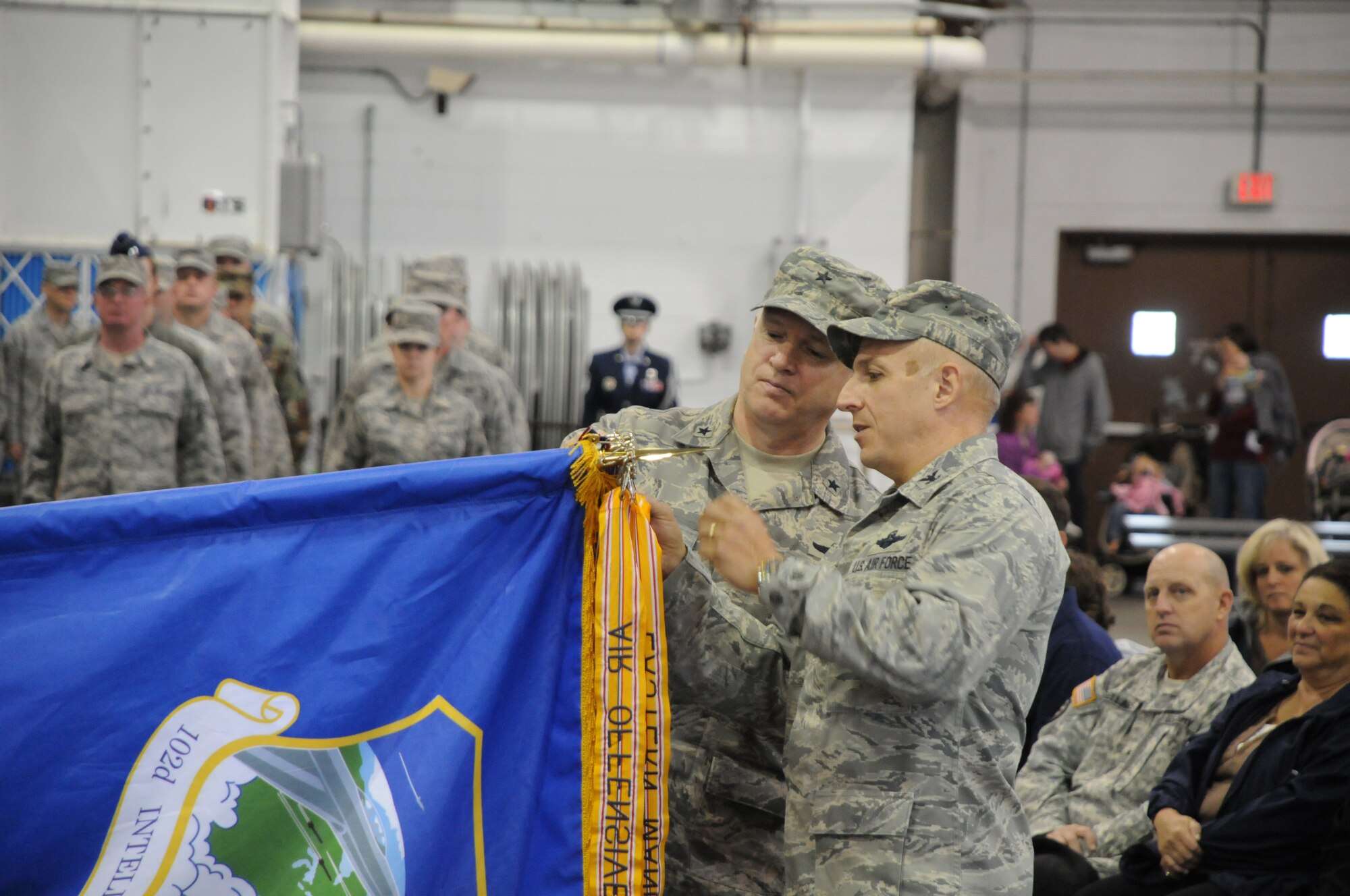 Brigadier General L. Scott Rice (left), Massachusetts Air National Guard commander, and Col. Anthony Schiavi (right), 102nd Intelligence Wing commander, add the 102nd Intelligence Wing's most recent Outstanding Unit Award banner to the 102nd Intelligence Wing flag, at the Wing's annual Family Day celebration, Oct. 3, 2010.  (U.S. Air Force photo by Master Sgt. Aaron Smith)