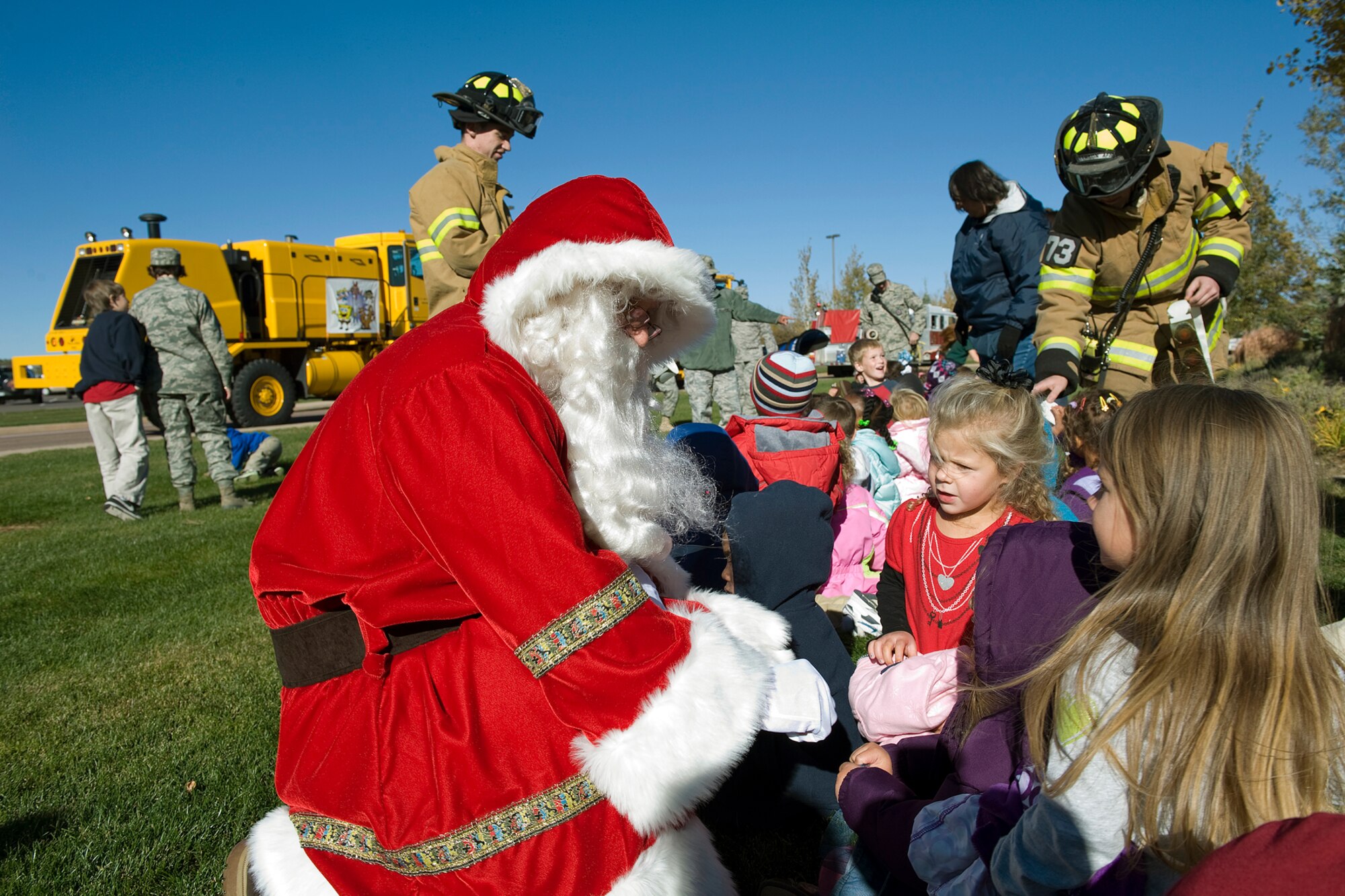 PETERSON AIR FORCE BASE, Colo. -- Santa Claus and firefighters from the 21st Civil Engineer Squadron greet children from the Child Development Center Oct. 27 during the annual “Snow Parade” on Peterson Boulevard. Children were treated to tours of the snow plows, fire trucks and dump trucks. The annual parade is a way to show off the CES equipment and crews who work to make Peterson roadways safe and emphasize the need to keep roadways clear and accessible for emergency vehicles. (U.S. Air Force photo/Craig Denton)
