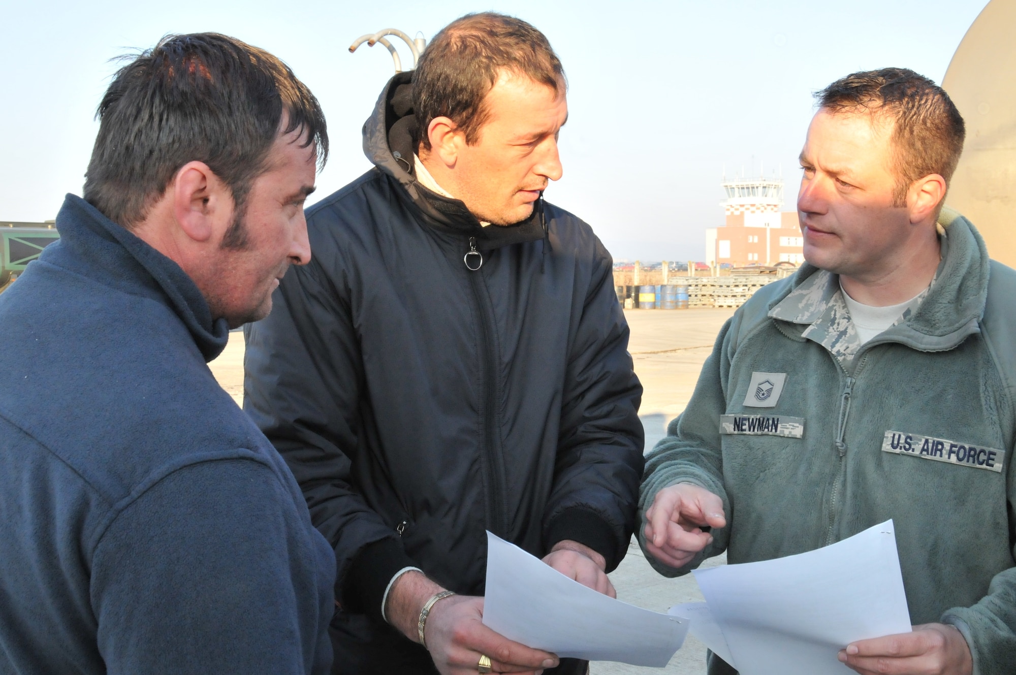CAMPIA TURZII AIR BASE, Romania – Master Sgt. Jeremy Newman (right), 48th Logistics Readiness Squadron NCO in charge of fuels distribution, discusses an invoice with Romanian fuel truck drivers Oct. 29. The fuel, for use by F-15 fighter aircraft participating in Operation Golden Lance, is brought from a terminal near the Romanian capital of Bucharest, eight hours from the base. (U.S. Air Force photo/Senior Airman David Dobrydney)