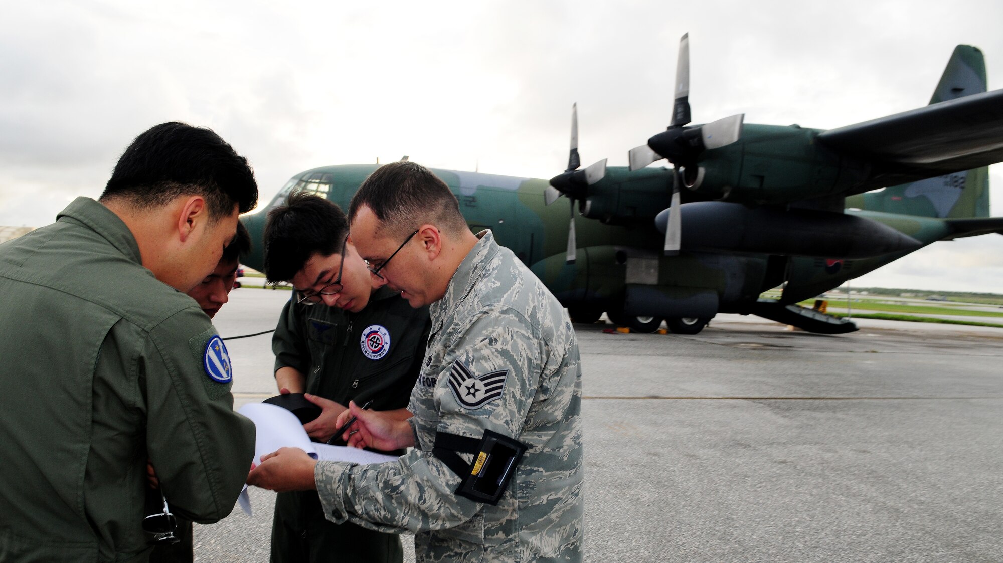 A U.S. Air Force Staff Sergeant from the 734th Air Mobility Squadron reviews documents with members of the Republic of Korea Air Force upon arrival to Andersen Air Force Base, Guam, Nov. 2, in a ROKAF C-130 aircraft. Cadets and officers from the ROKAF visited Andersen AFB to promote and strengthen the close ties between the allied nations. (U.S. Air Force photo/ Senior Airman Nichelle Anderson)