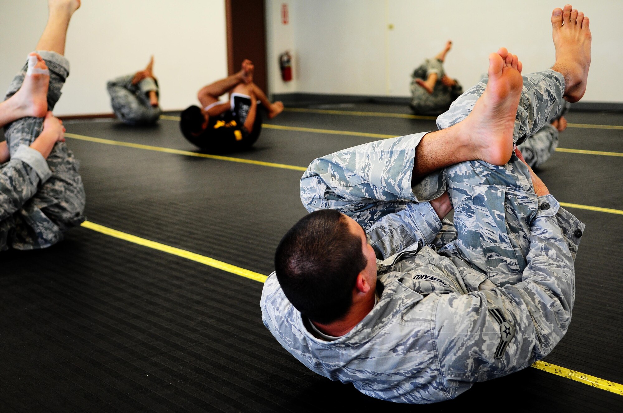Airmen from the 736th Security Forces Squadron perform stretches during an Army Modern Combatives class hosted by the Guam Army National Guard at Fort Juan Muna, Oct. 20. The Airmen learned various styles of combative techniques including Jujitsu and grappling. (U.S. Air Force/Airman Jeffrey Schultze/Released)