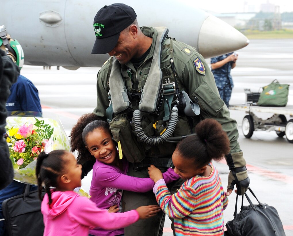 U.S. Navy Lt. Cmdr. Victor Glover greets his daughters at the Naval Air Facility Atsugi during the first part of the squadron's homecoming celebration in Atsugi, Japan, Oct. 26, 2010. Glover is assigned to the Dambusters of Strike Fighter Squadron 195.