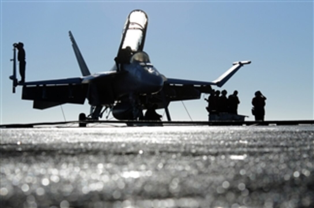 U.S. Navy sailors assigned to Strike Fighter Squadron 154 prepare a Navy F/A-18F Super Hornet aircraft for the first launch cycle of the day aboard the aircraft carrier USS Ronald Reagan (CVN 76) while underway in the Pacific Ocean on Nov. 2, 2010.  Sailors with the squadron are embarked to complete a composite training unit exercise in preparation for a deployment.  