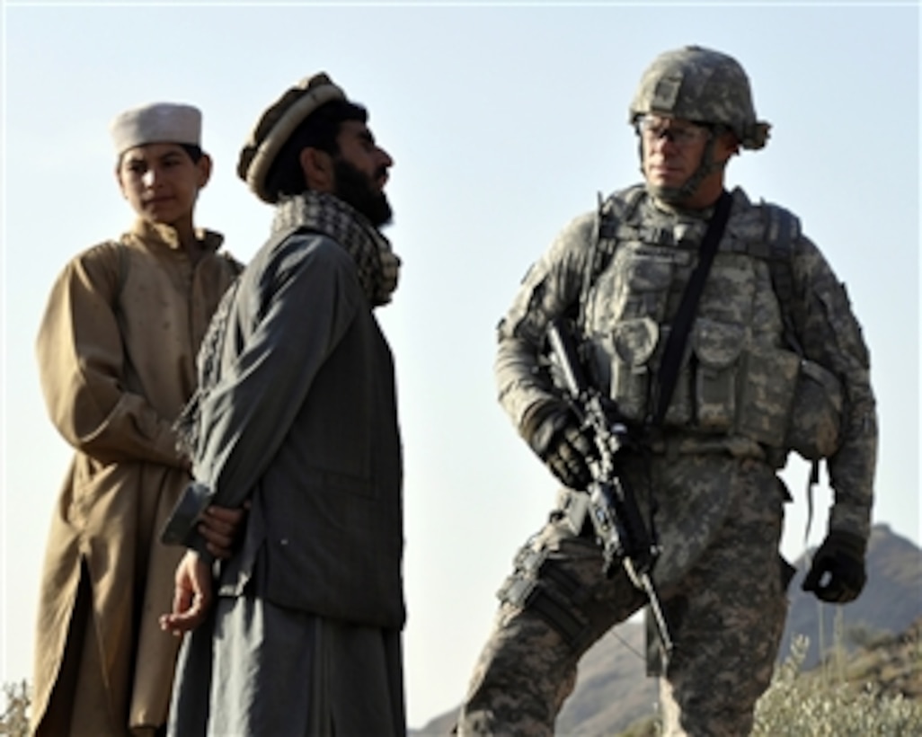 U.S. Navy Cmdr. Bill Mallory (right), commanding officer of the Nuristan Provincial Reconstruction Team, listens to a Kautiak village leader in the Nuristan province of Afghanistan on Oct. 30, 2010.  The Provincial Reconstruction Team members visit Afghan residents to determine sources of instability, enhance support for the government and recommend improvements to their communities.  