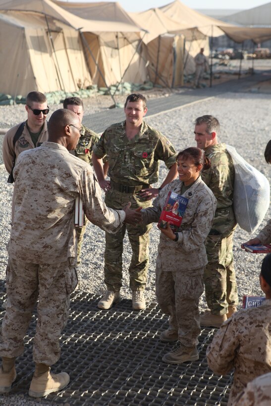 Navy Cmdr. Herbert Griffin, the 3rd Marine Aircraft Wing (Forward) command chaplain, distributes recordible holiday books to servicemembers at the 3rd MAW (Fwd) compound aboard Camp Leatherneck, Afghanistan, Nov. 4. The books were donated to deployed service members, who were able to record their voices reading the books and mail them home to family and loved ones for the holiday season.::r::::n::::r::::n::::r::::n::