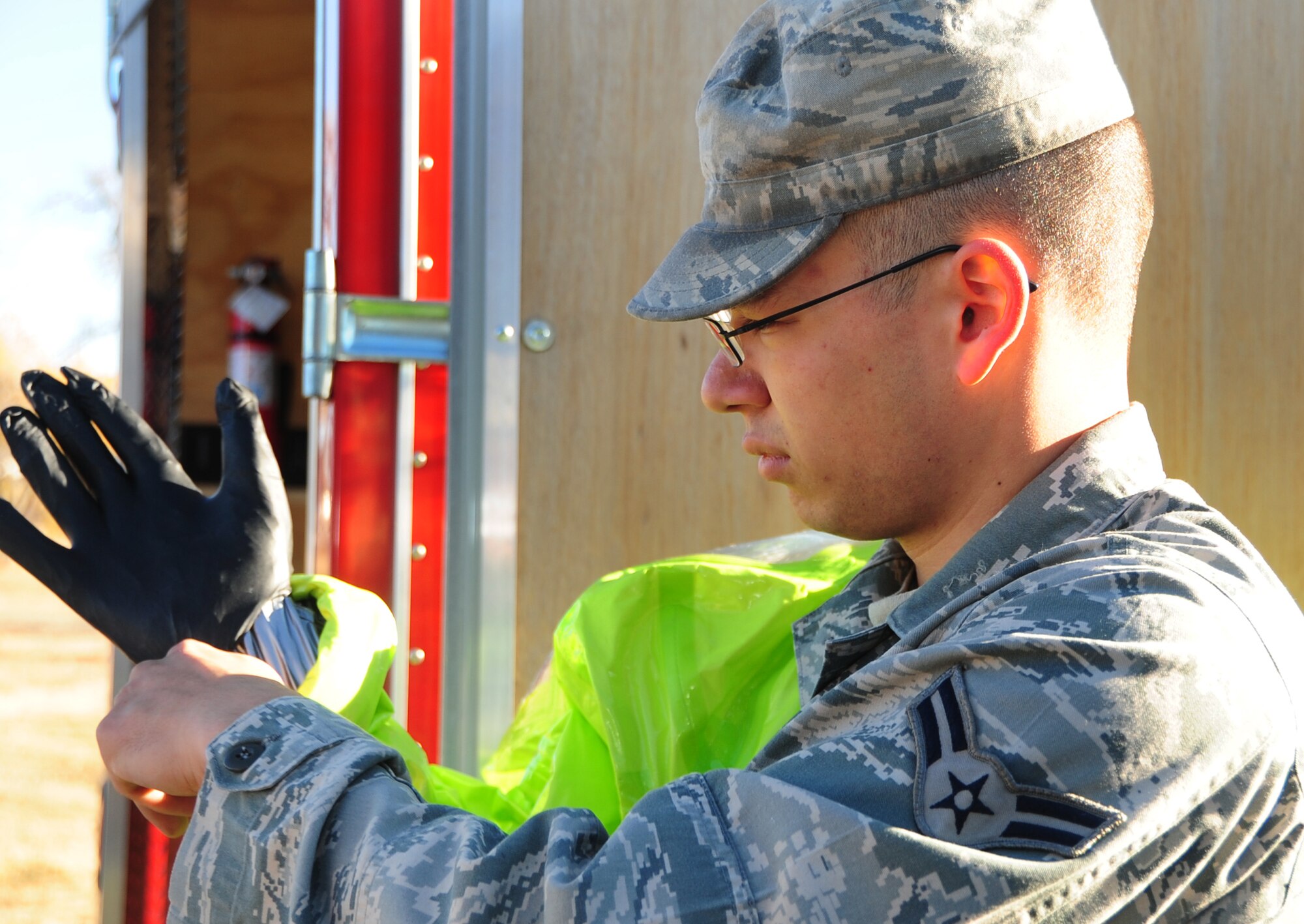 ELLSWORTH AIR FORCE BASE, S.D. - Airman 1st Class Matthew Hung, 28th Civil Engineering Squadron emergency management journeyman, puts on a chemical protection suit during a joint training mission with the Army National Guard and the Rapid City Fire Department in Rapid City, S.D., Nov 4.  The chemical protective suit is designed to keep Airman Hung safe from simulated chemicals and radiation during the training. (U.S. Air Force photo/Senior Airman Anthony Sanchelli)

