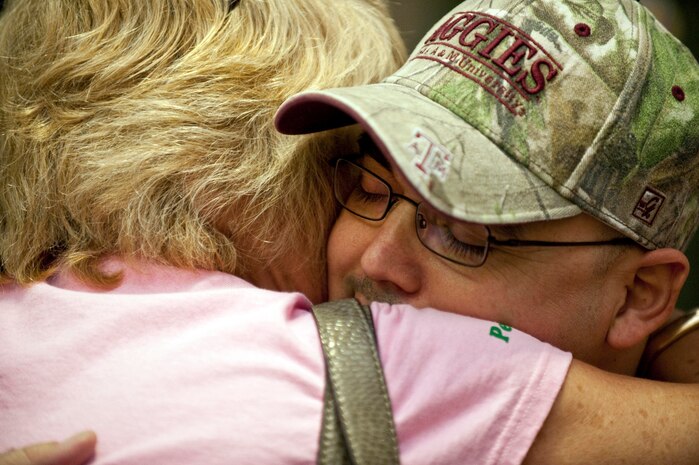 LAS VEGAS -- Master Sgt. Christopher Aguilera, an aerial gunner assigned to the 66th Rescue Squadron receives a hug from Dena Hill at McCarran International airport Nov. 4. Sergeant Aguilera returned to Las Vegas and Nellis Air Force Base, Nev., after spending the past four months at Brooke Army Medical Center in San Antonio, Texas recovering from injuries he received during an HH-60G Pave Hawk helicopter crash in southwest Afghanistan June 9, 2010 which killed five Airmen. (U.S. Air Force photo / Tech. Sgt. Michael R. Holzworth)(Released)
