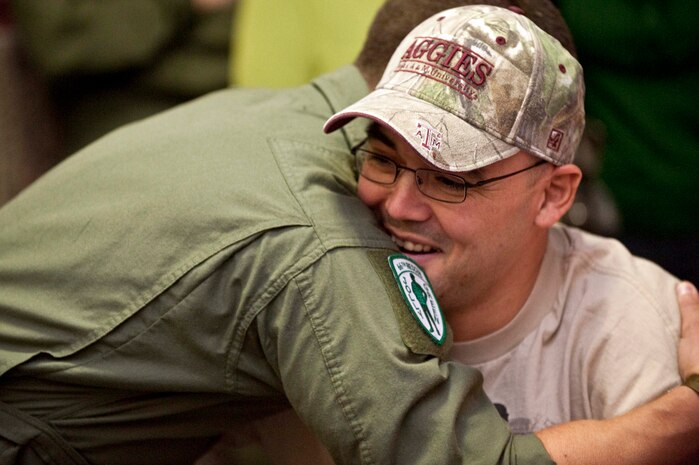 LAS VEGAS -- Master Sgt. Christopher Aguilera, an aerial gunner assigned to the 66th Rescue Squadron receives a hug from a fellow Airmen at McCarran International airport Nov. 4. Sergeant Aguilera returned to Las Vegas and Nellis Air Force Base, Nev., after spending the past four months at Brooke Army Medical Center in San Antonio, Texas recovering from injuries he received during an HH-60G Pave Hawk helicopter crash in southwest Afghanistan June 9, 2010. (U.S. Air Force photo / Tech. Sgt. Michael R. Holzworth)(Released)

